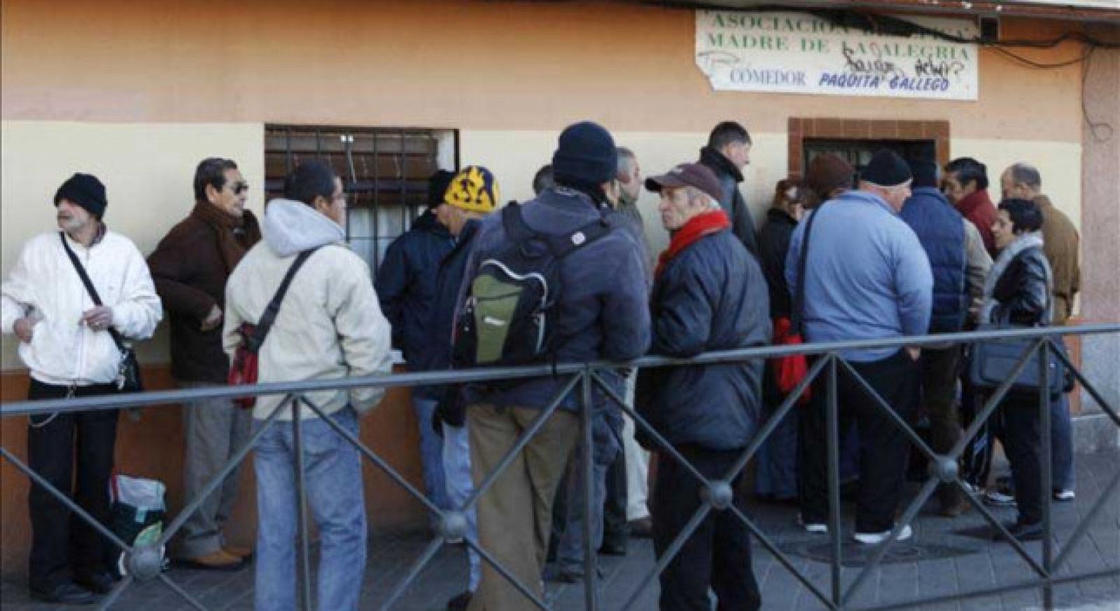 Un grupo de personas guardan cola para acceder a un comedor social