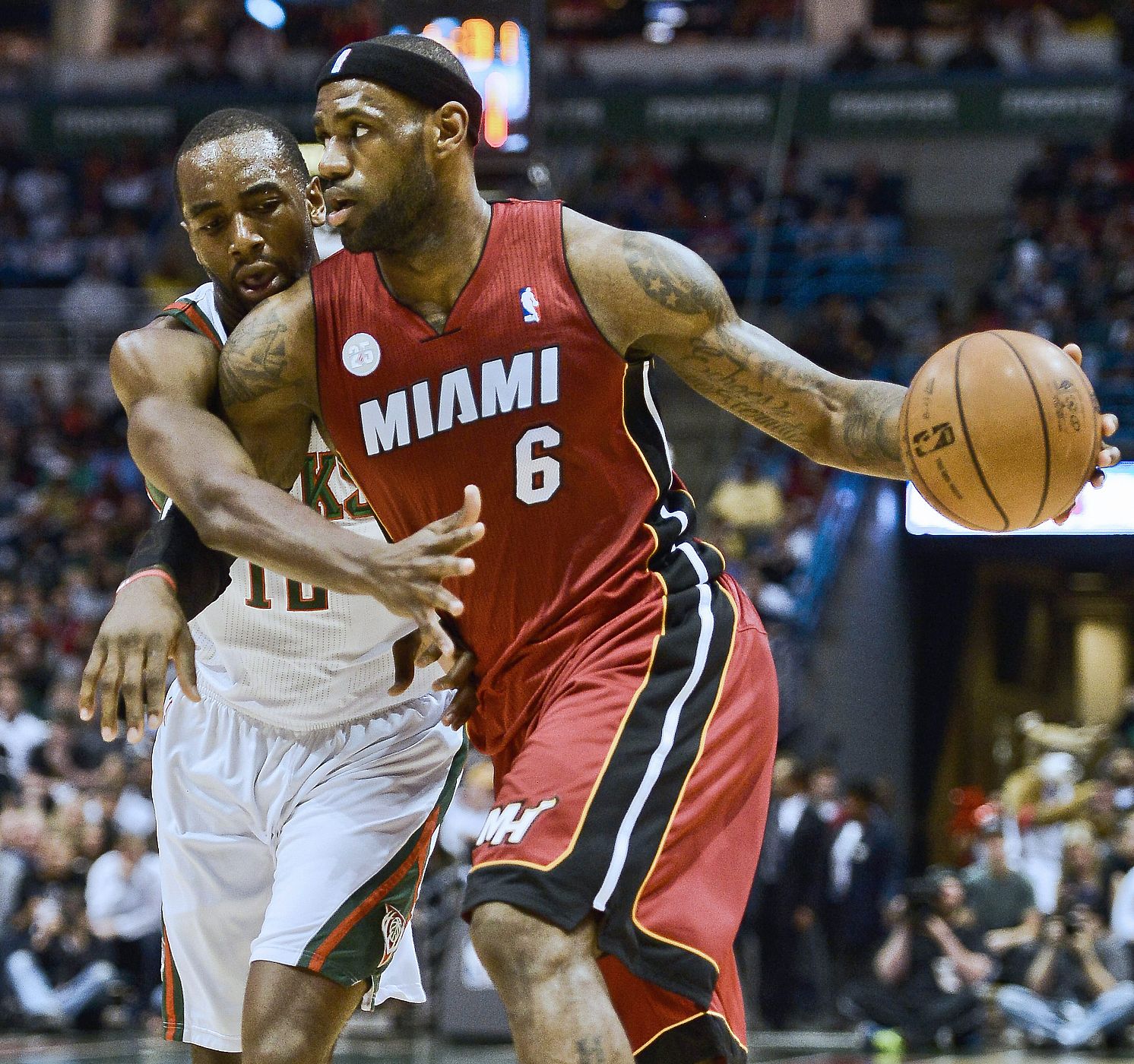 LeBron James (d) de los Heat supera a  Luc Richard Mbah de los Bucks en los 'play-offs' de la NBA