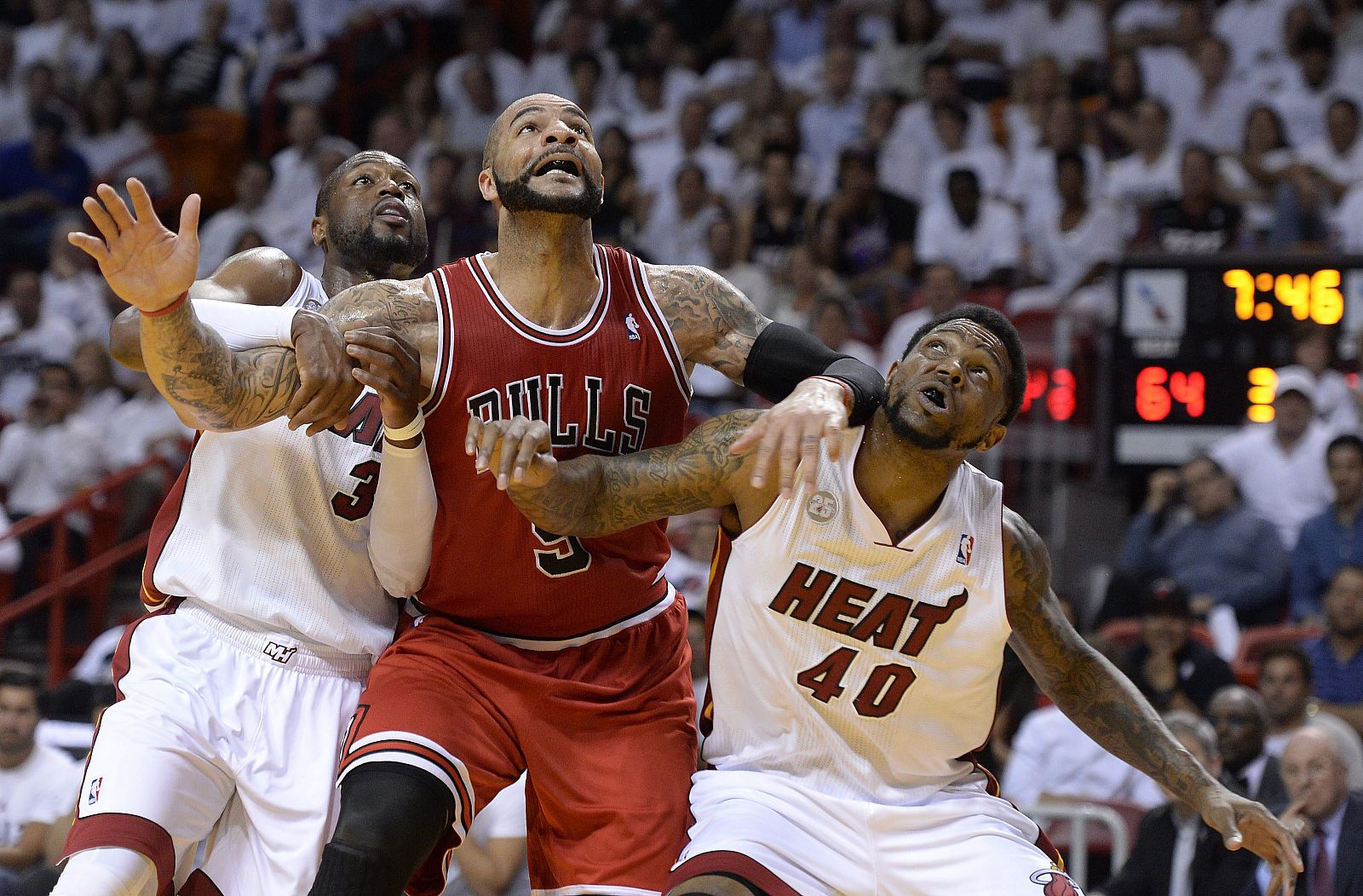 Los jugadores de los Heat Dwyane Wade (i) y Udonis Haslem (d) ante Carlos Boozer (c) de los Bulls, durante la fase final de la NBA