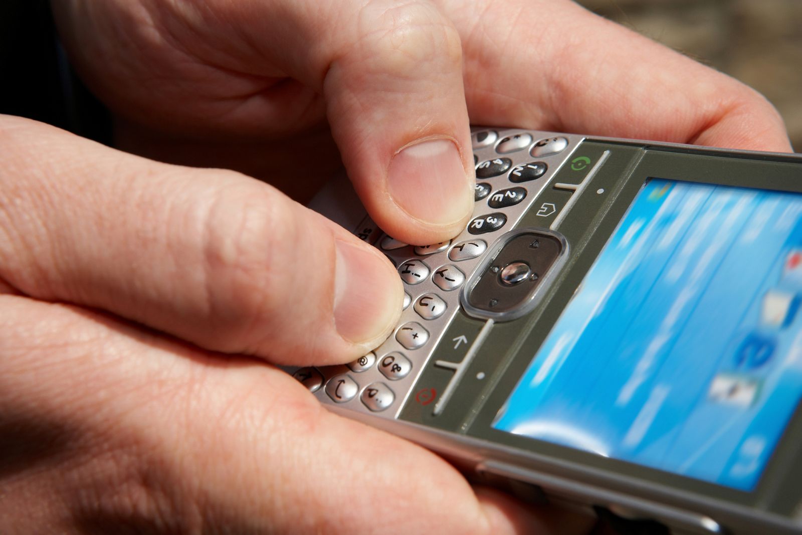 Un hombre enviando un mensaje desde su smartphone.