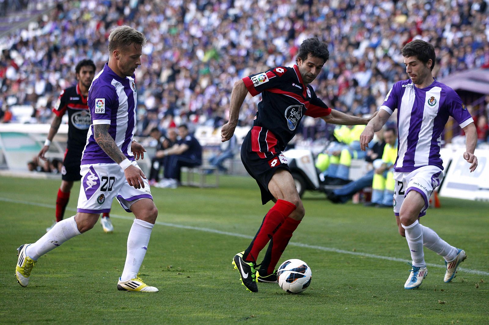 El centrocampista del Deportivo Juan Carlos Valerón pelea un balón con los jugadores del Valladolid Patrick Ebert y Víctor Pérez.