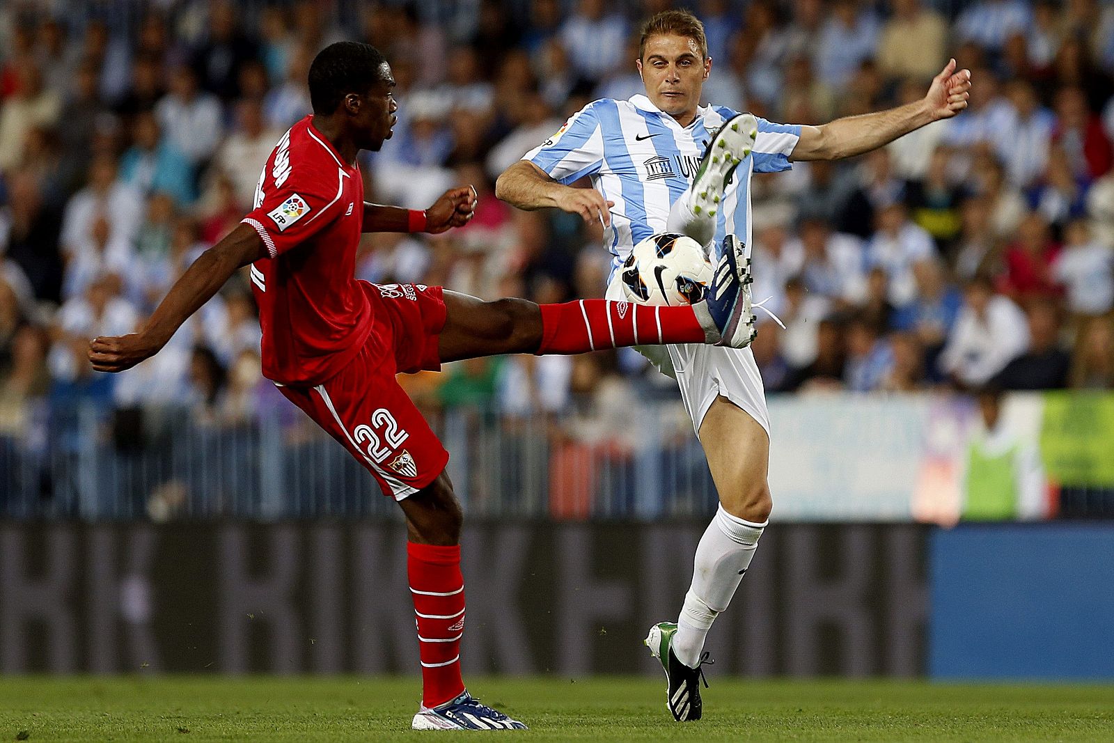 El jugador del Málaga Joaquín Sánchez disputa un balón con el francés Geoffrey Kondogbia, del Sevilla.