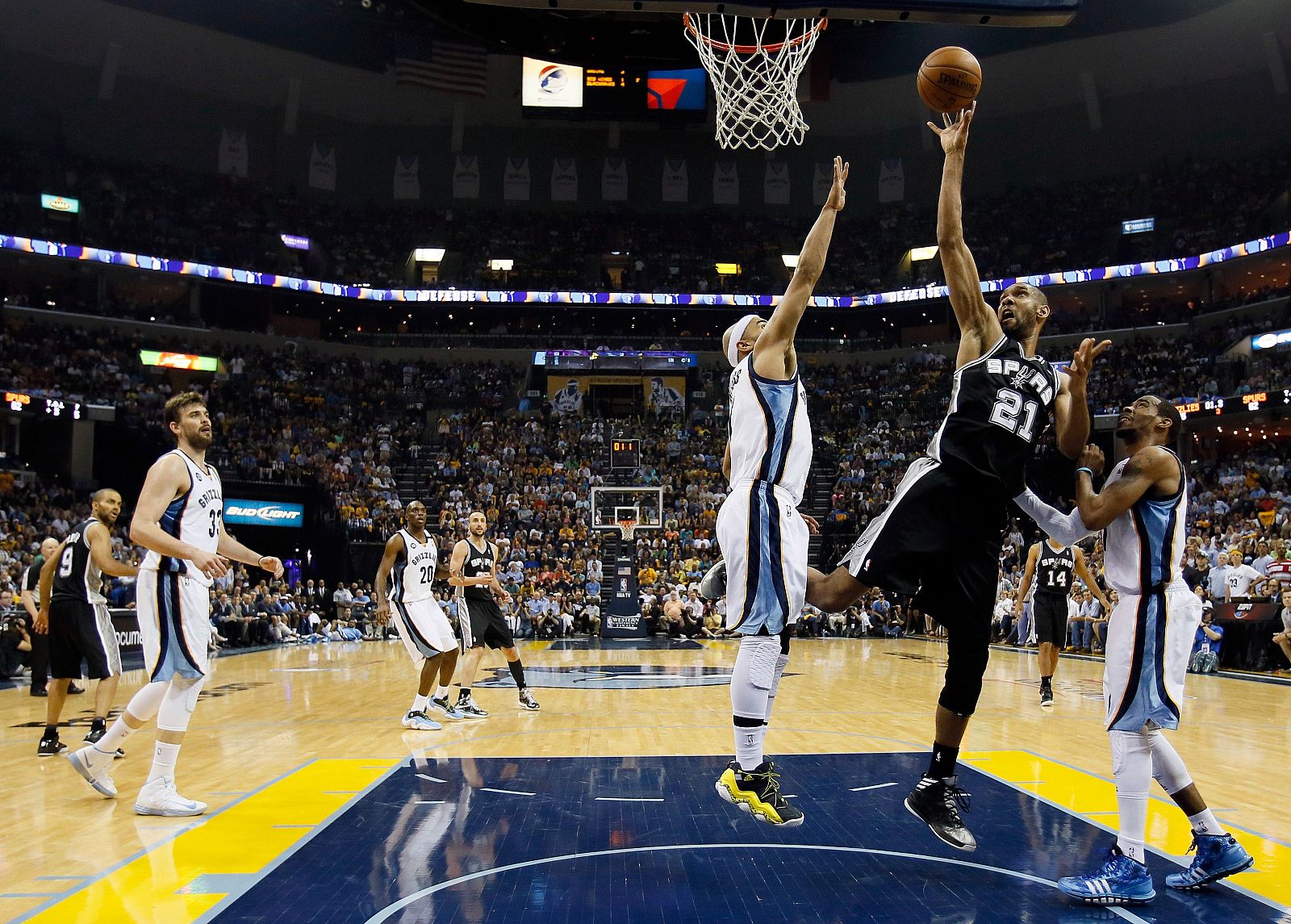 Tim Duncan, de los Spurs, tira a canasta ante la oposición de dos jugadores de los Grizzliez y Marc Gasol de fondo
