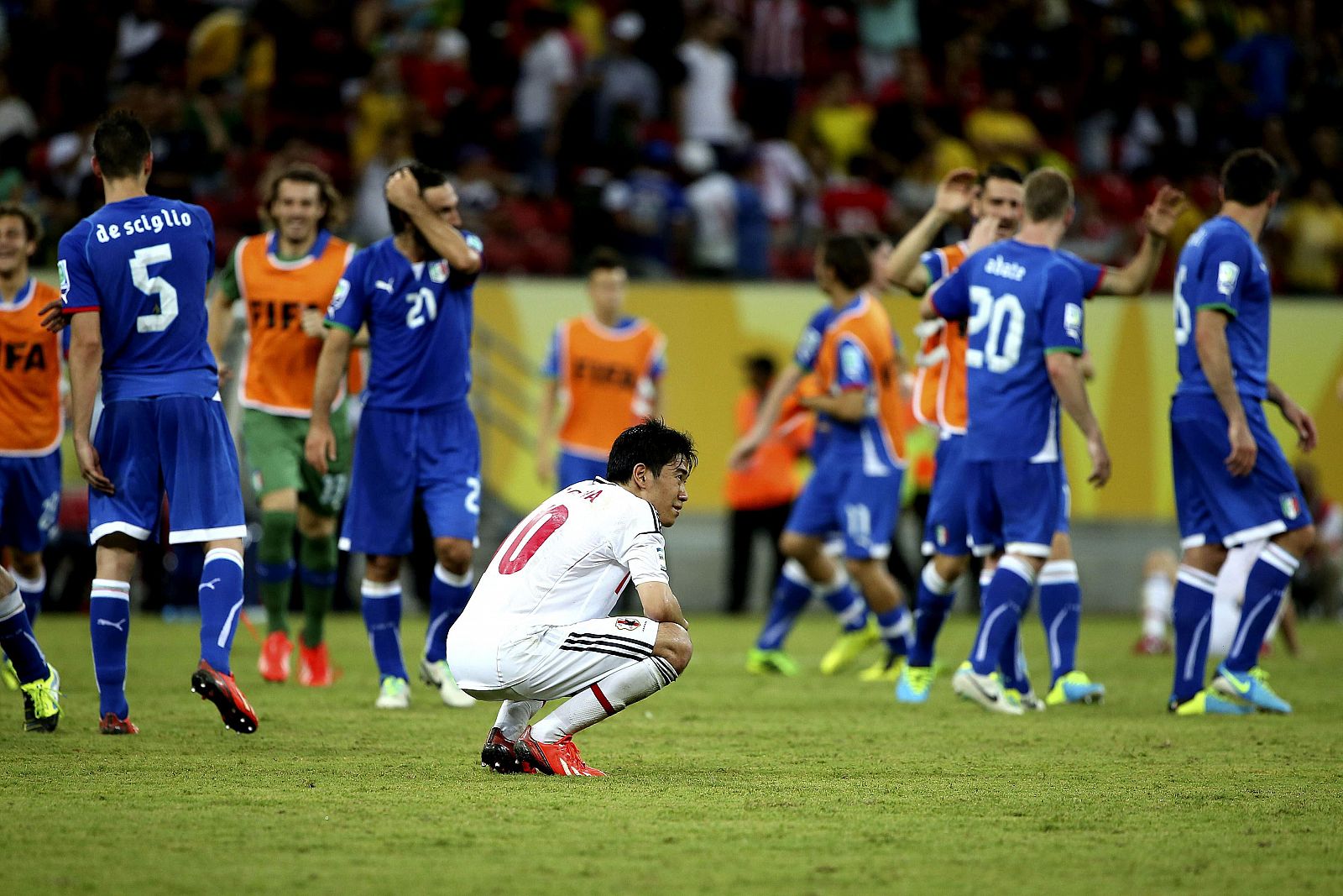 Los jugadores italianos, junto al japonés Shinji Kagawa (c), celebran la victoria sobre Japón