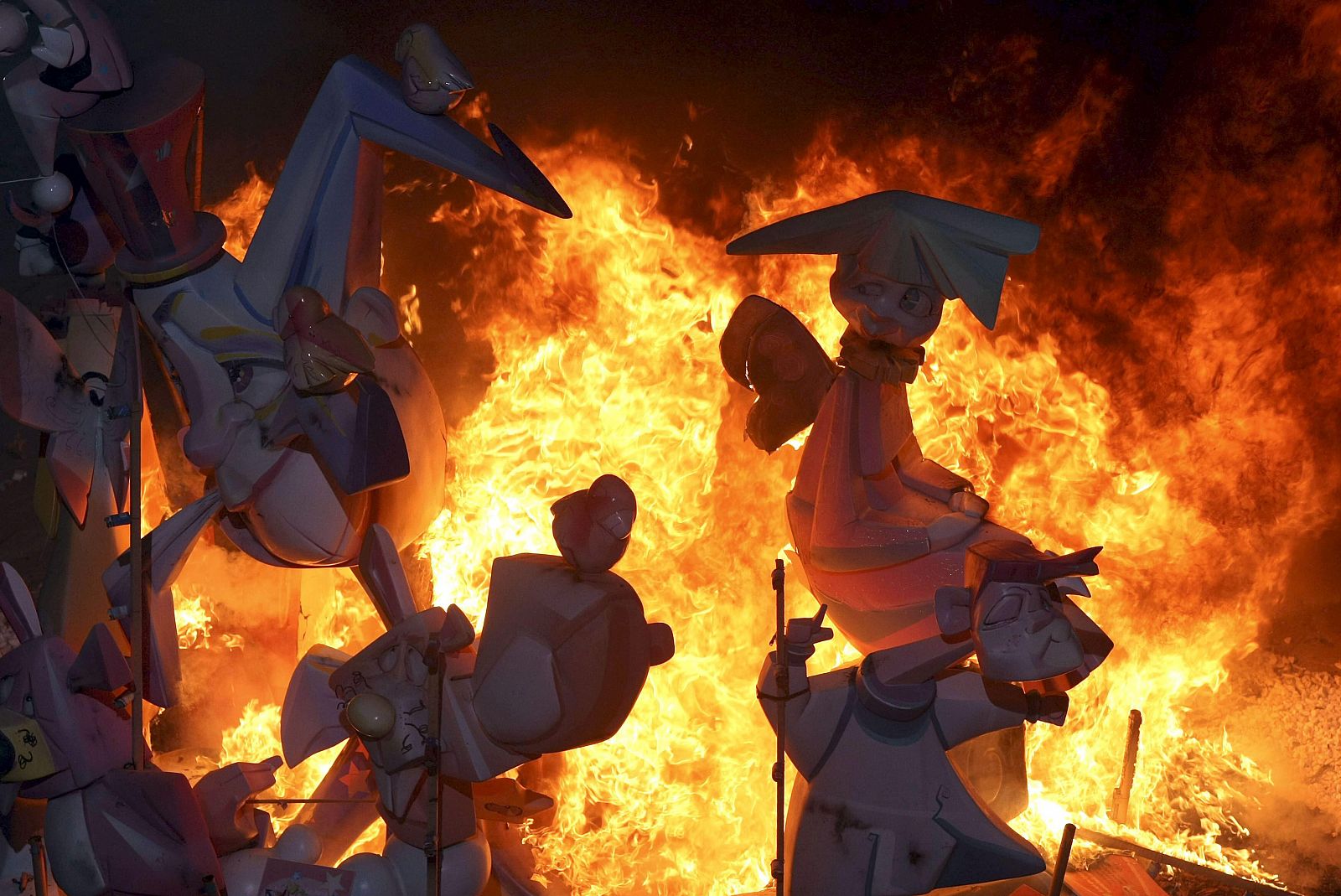 La hoguera oficial infantil arde en la Plaza del Ayuntamiento en el inicio de la "Nit de la Cremá"