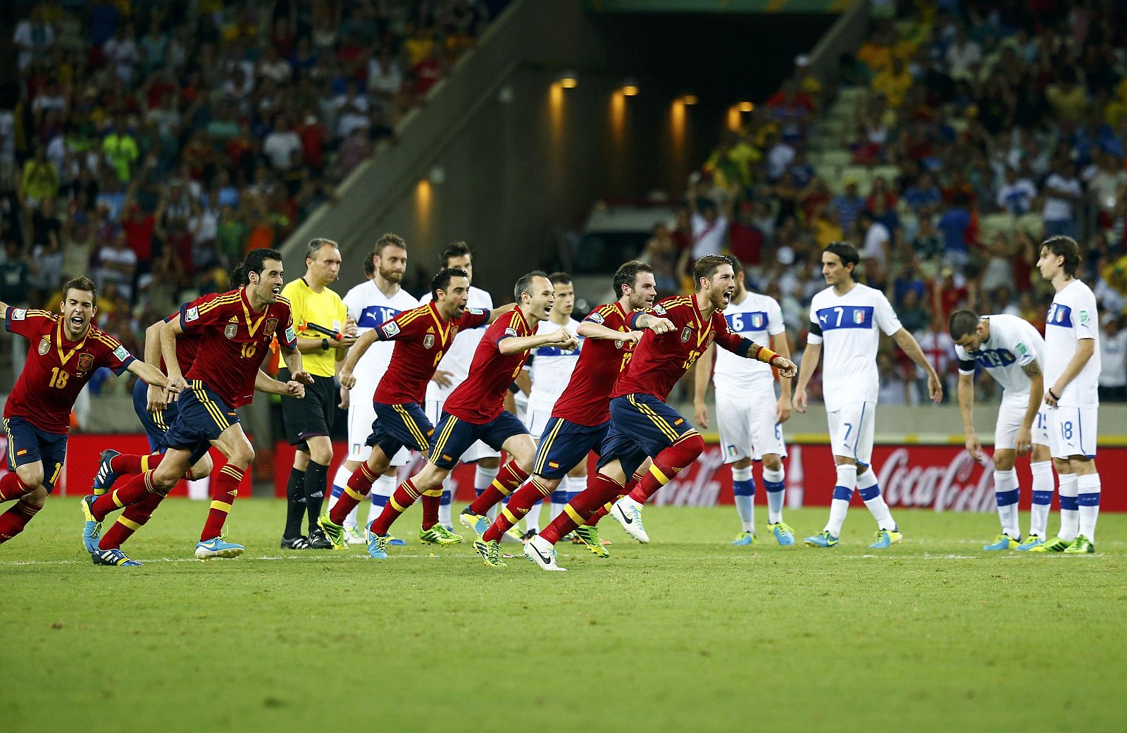 Los jugadores de España celebran la victoria ante el desconsuelo de los jugadores de Italia.