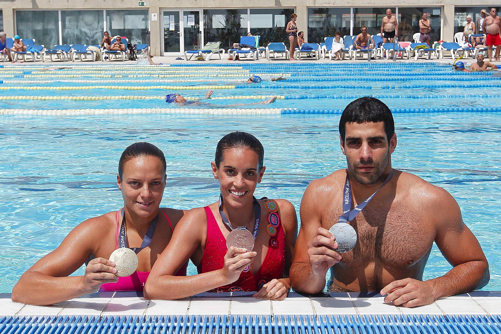 Los deportistas Marc Minguells (d), Jennifer Pareja (i), y Ona Carbonell (c), muestran las medallas del Mundial de Natación 2013.