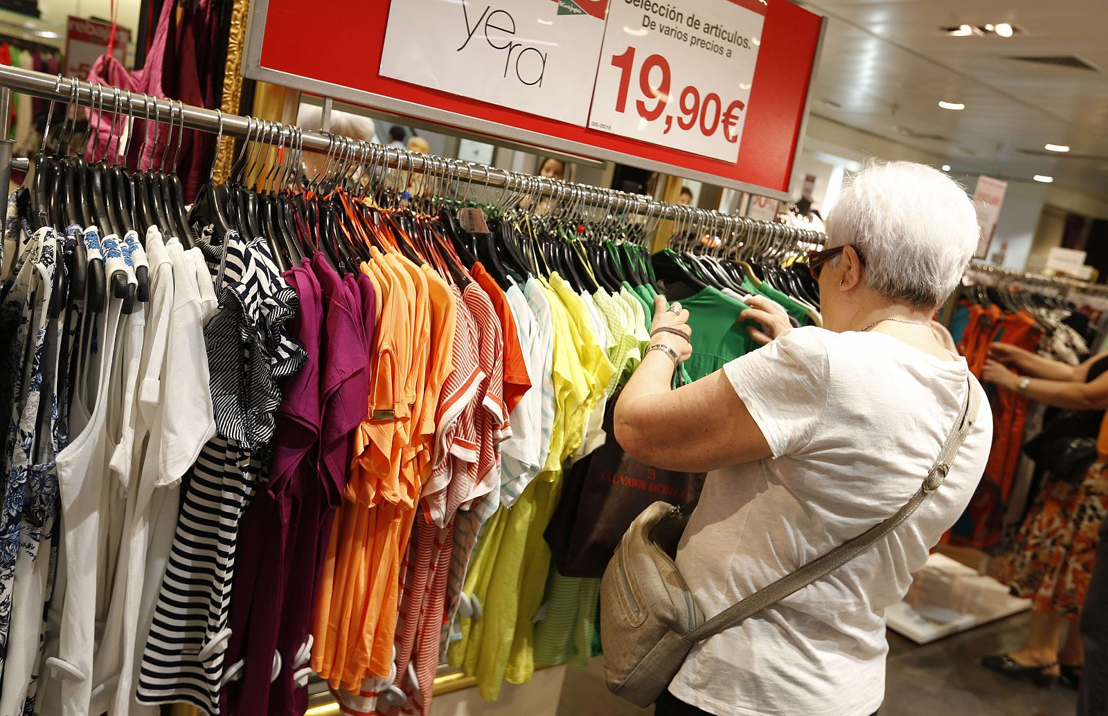 Una mujer mira las ofertas de ropas en unos grandes almacenes.