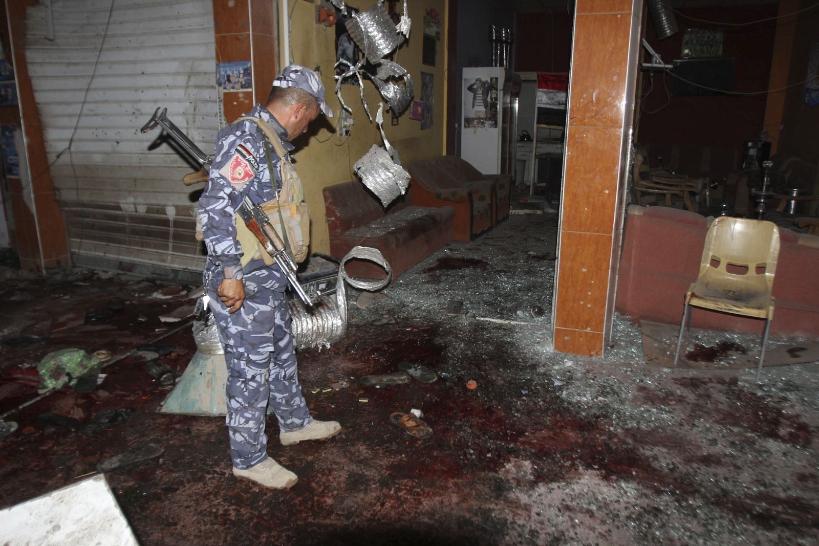 Un policía inspecciona el lugar del atentado con bomba en un café en Kirkuk, a 250 kilómetros al norte de Bagdad, en el que han muerto al menos 38 personas según la policía y lo médicos. La explosión ha tenido lugar en una cafetería donde se habían