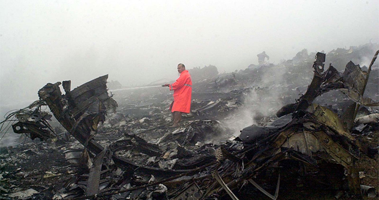 Un bombero turco intenta extinguir las llamas del Yak-42, que quedó completamente destrozado.