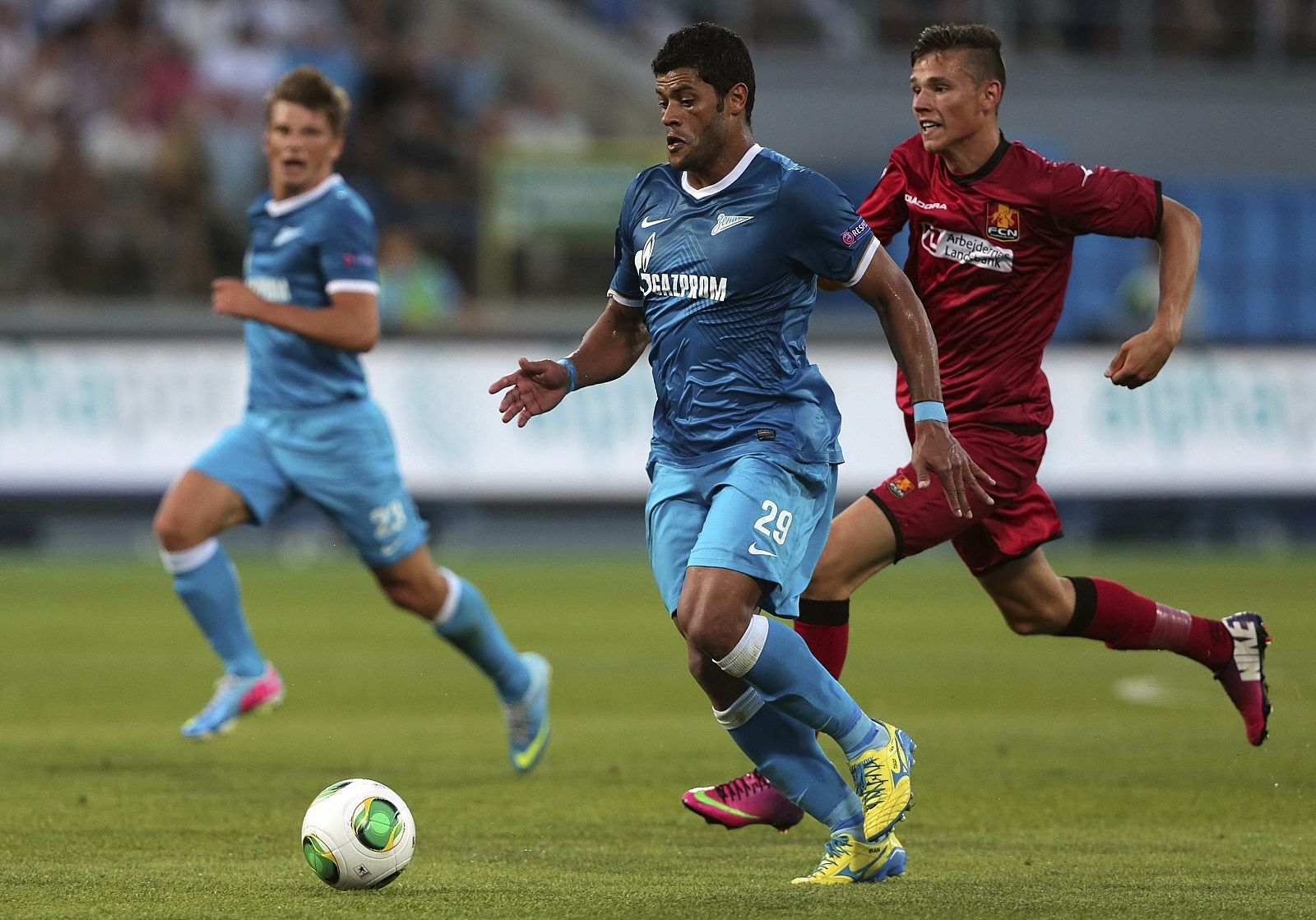 Pascal Gregor, del Nordsjaelland, pelea por el balón con el brasileño Hulk y su compañero Andrey Arshavin, del Zenit San Petersburgo.