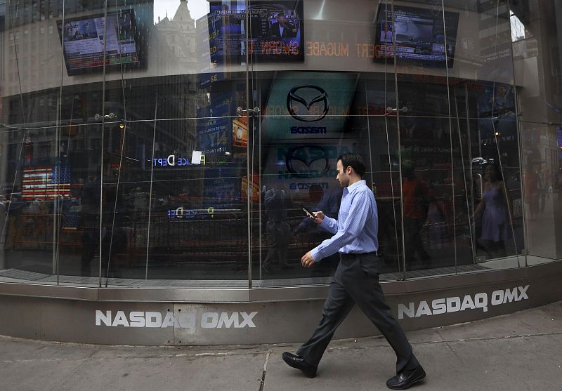 Un hombre camina delante del "Nasdaq MarketSite" en Nueva York