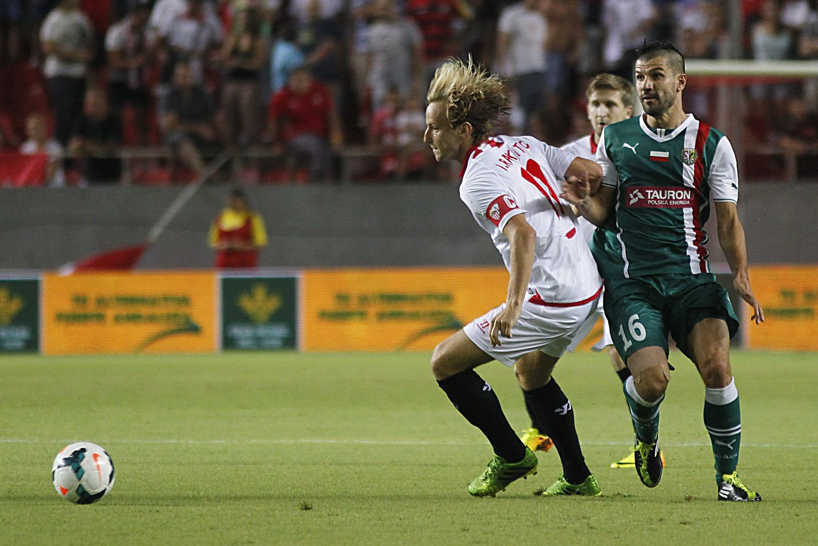 El jugador del Sevilla FC, Rakitic, choca con el jugador del Slask Wroclaw, Stevanovic.