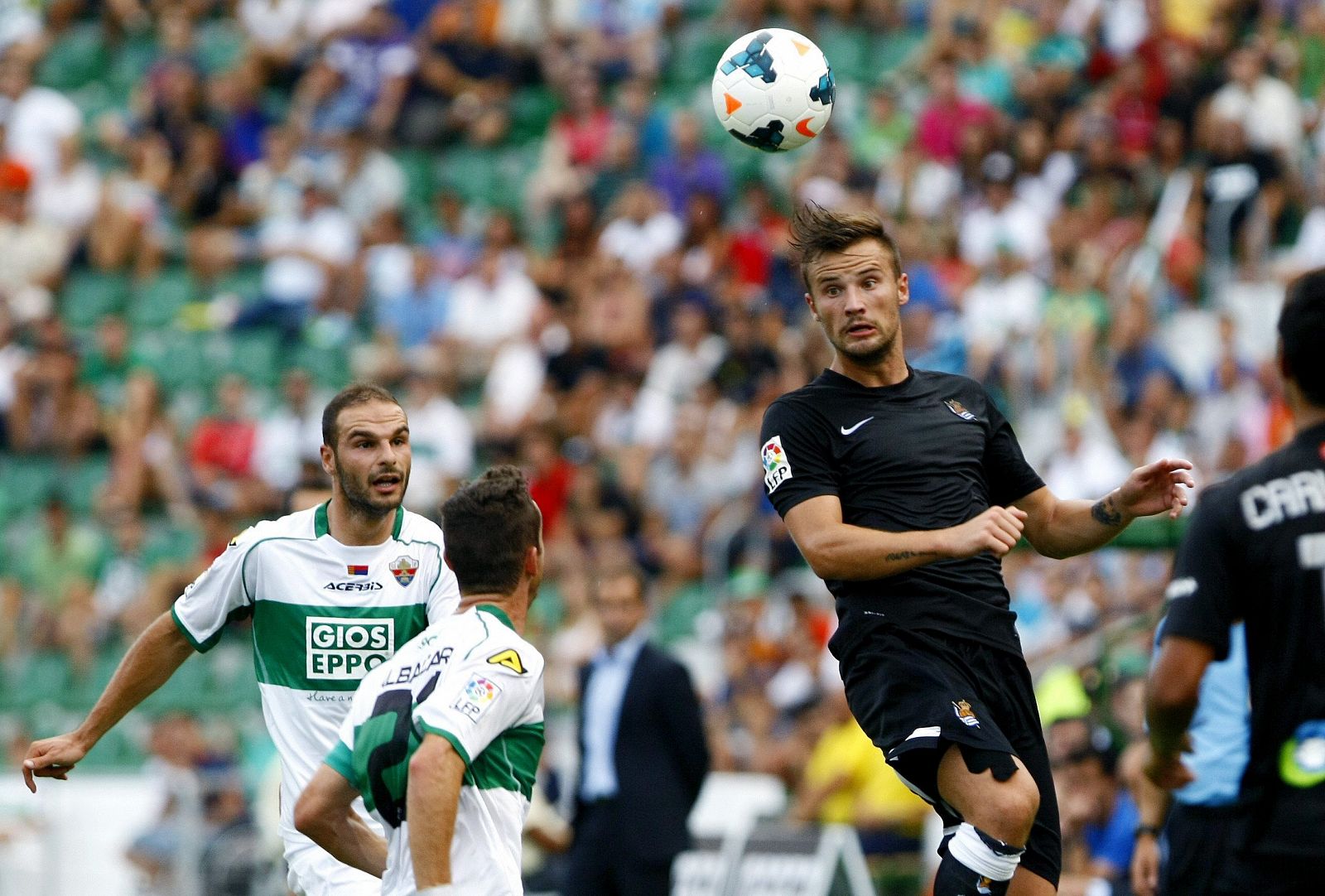 Seferovic (d) despeja un balón de cabeza ante el defensa del Elche, David Lombán (i).