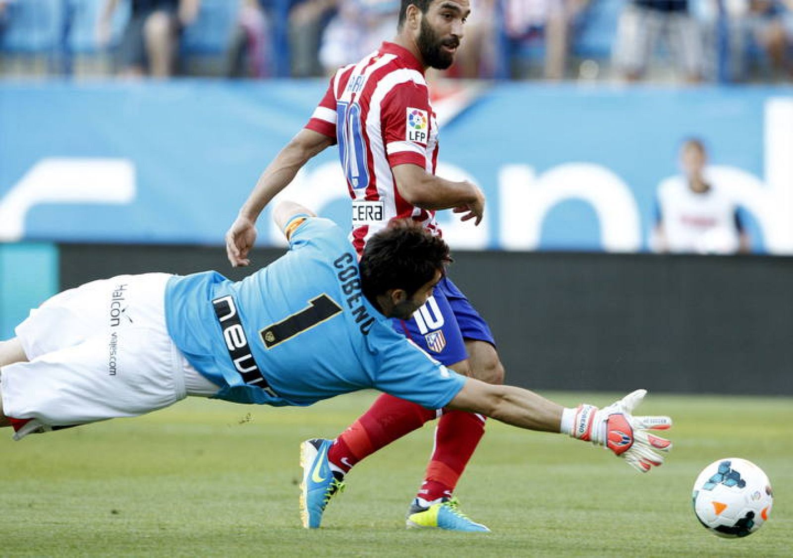 El jugador del Atlético de Madrid, Arda (d), bate al portero del Rayo Vallecano, Cobeño