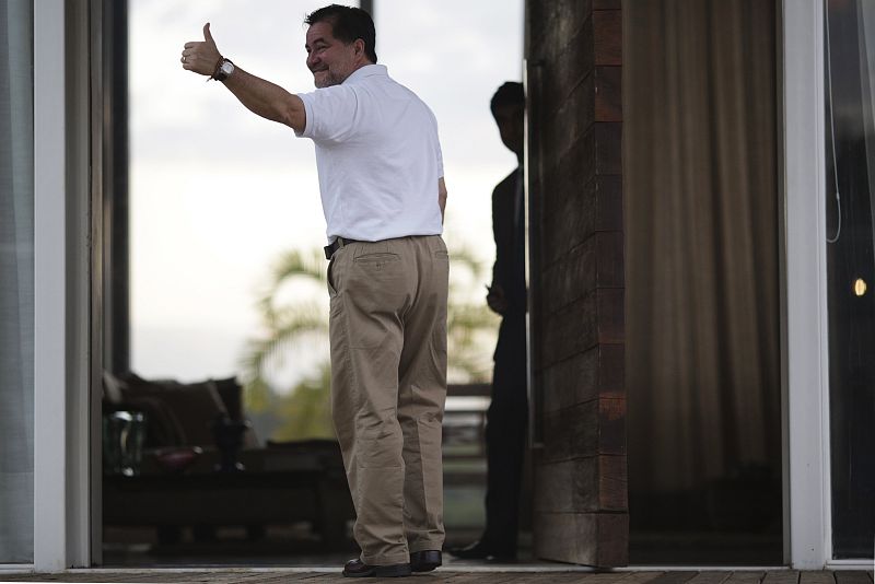 El senador boliviano Roger Pinto saluda con un gesto desde la entrada principal de la residencia del abogado Fernando Tiburcio en Brasilia.