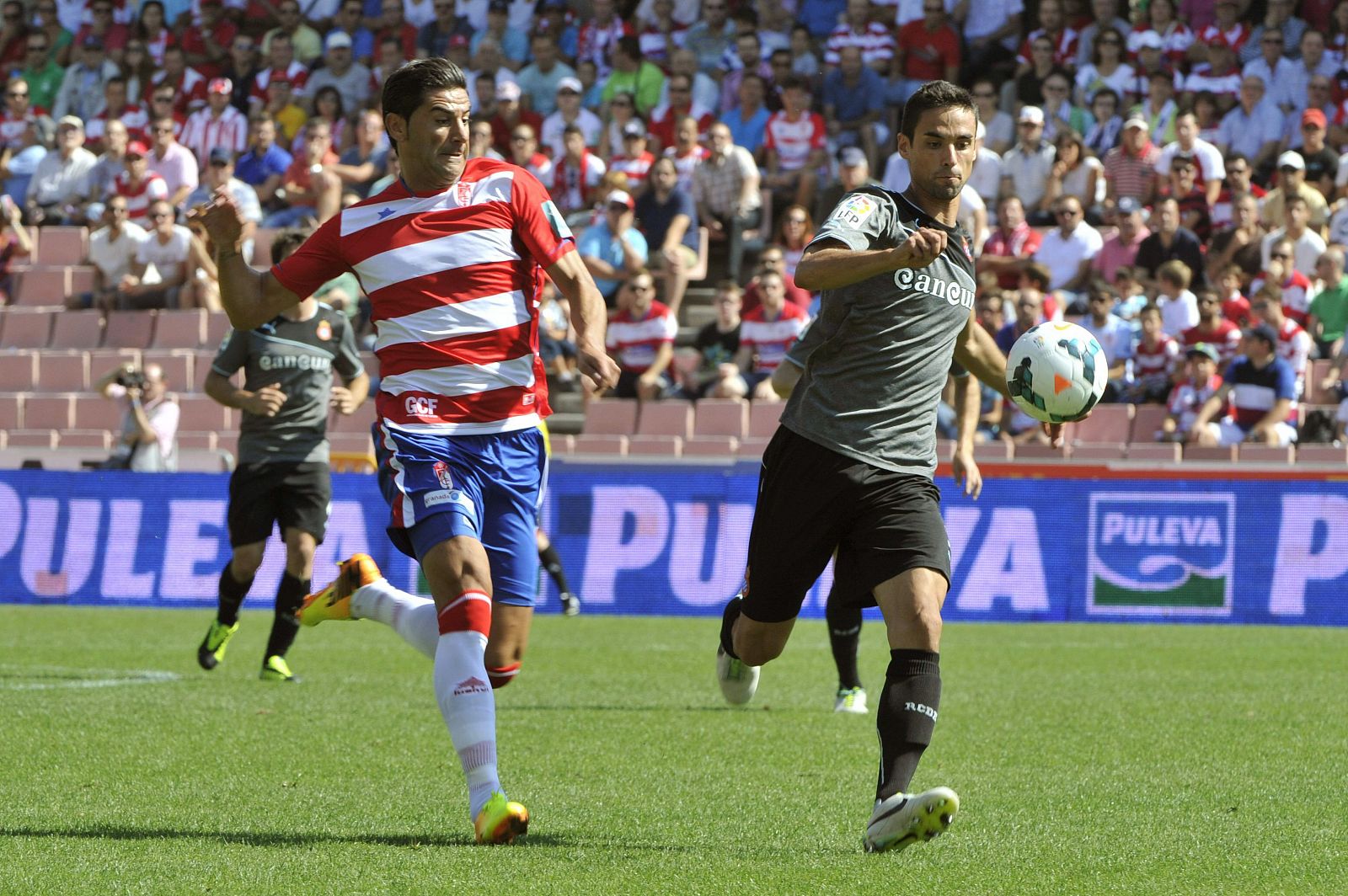 "Riki" (i), pelea por el balón con el defensa del Espanyol, Raúl Rodríguez (d), durante el encuentro.
