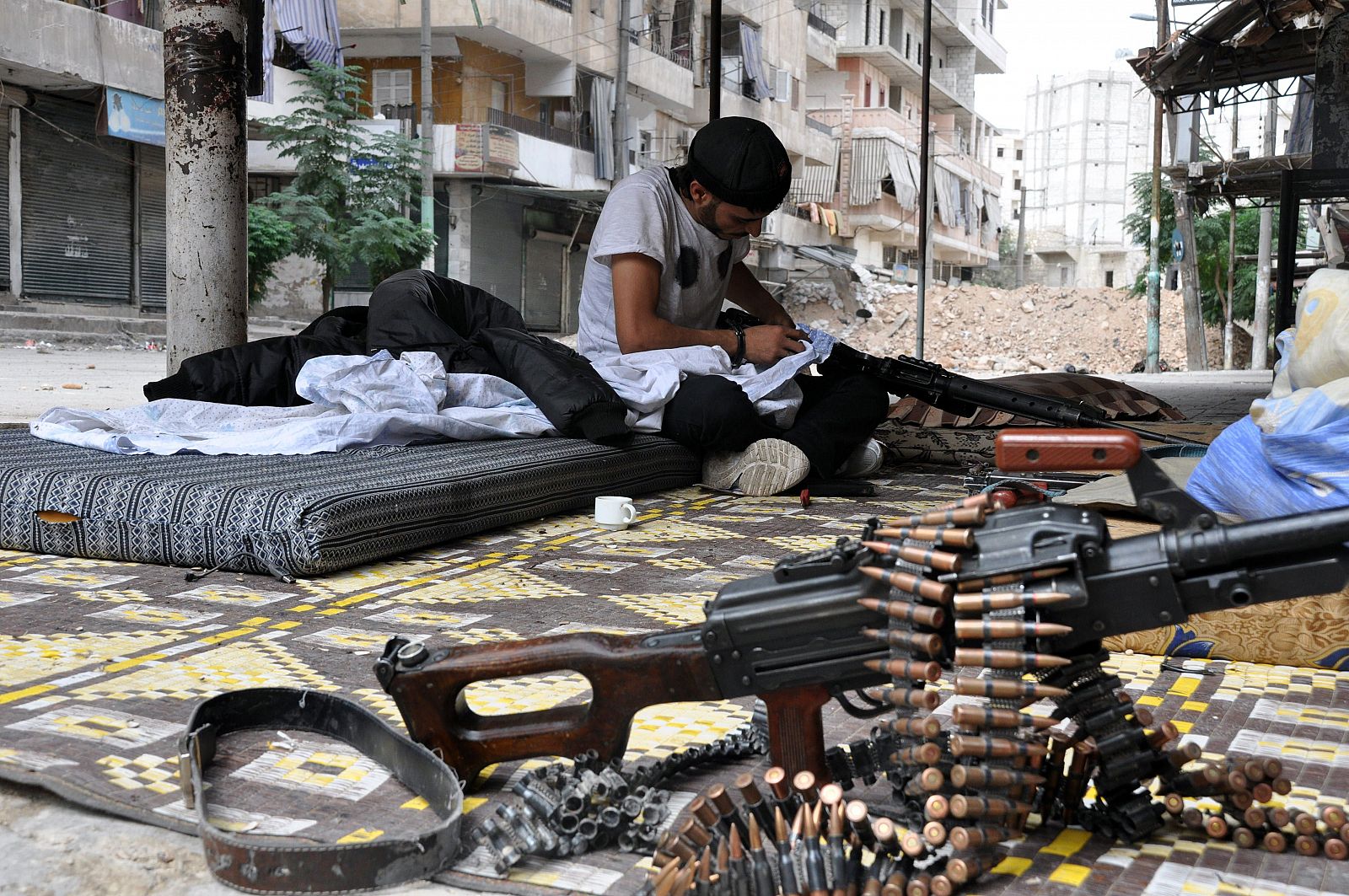 Un miliciano rebelde limpia su arma en Alepo