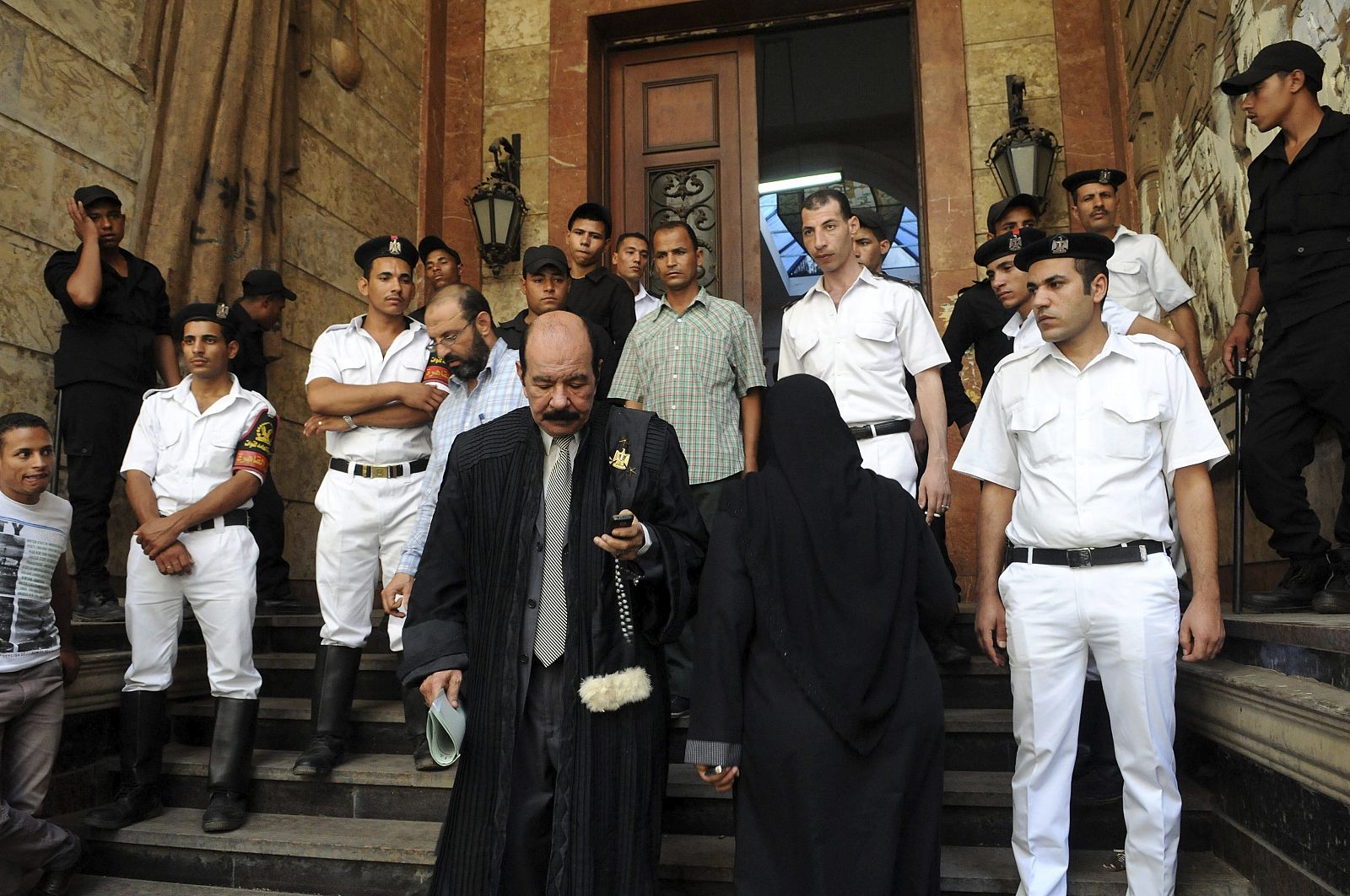 Un abogado (c) sale del tirbunal mientras unos soldados hacen guardia en El Cairo
