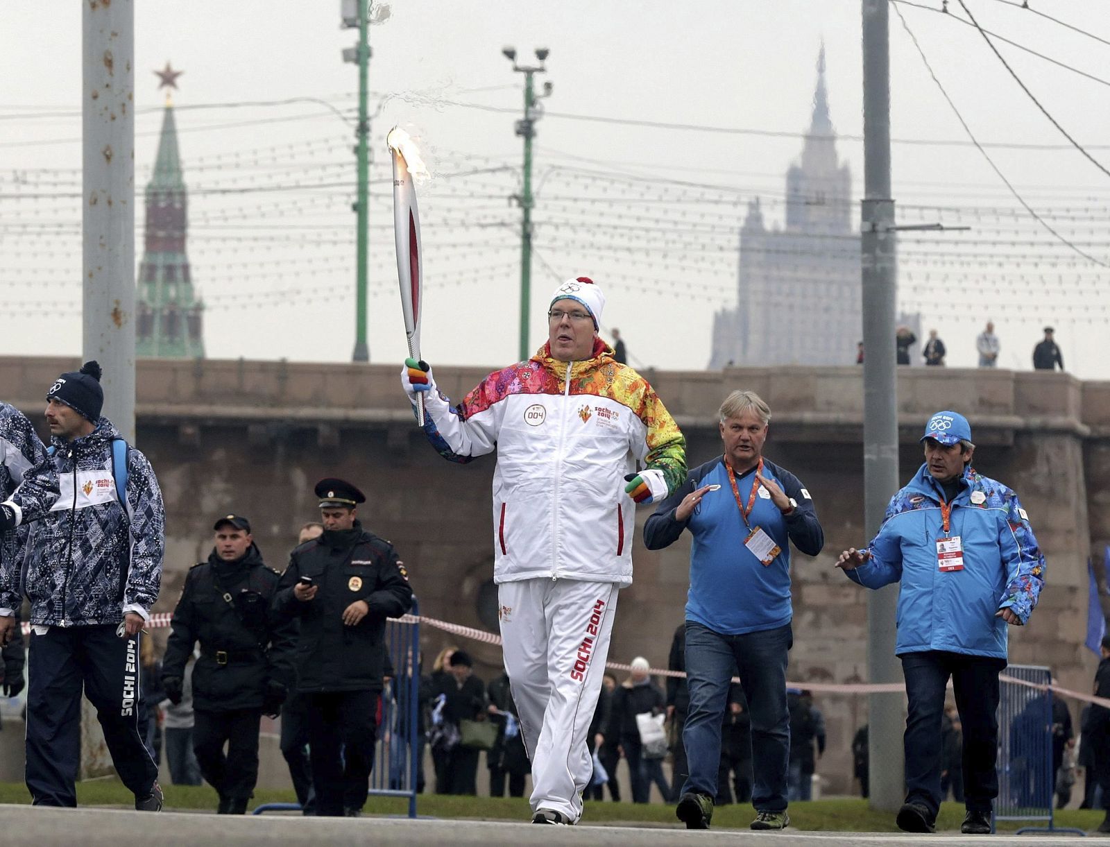 El príncipe Alberto de Mónaco (centro) porta la antorcha olímpica de Sochi 2014 por las calles de Moscú (Rusia)