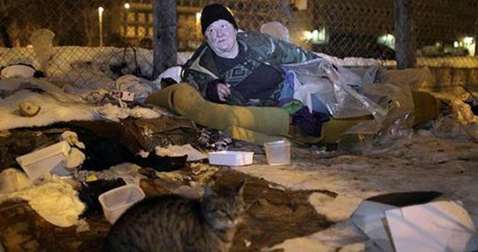 Una mujer sin hogar descansa en un saco de dormir en un parque público en Budapest.