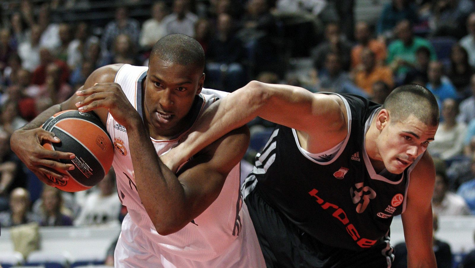 Marcus Slaughter (i) lucha un balón con el pívot alemán del Brose Baskets Mail Zirbes durante el partido.
