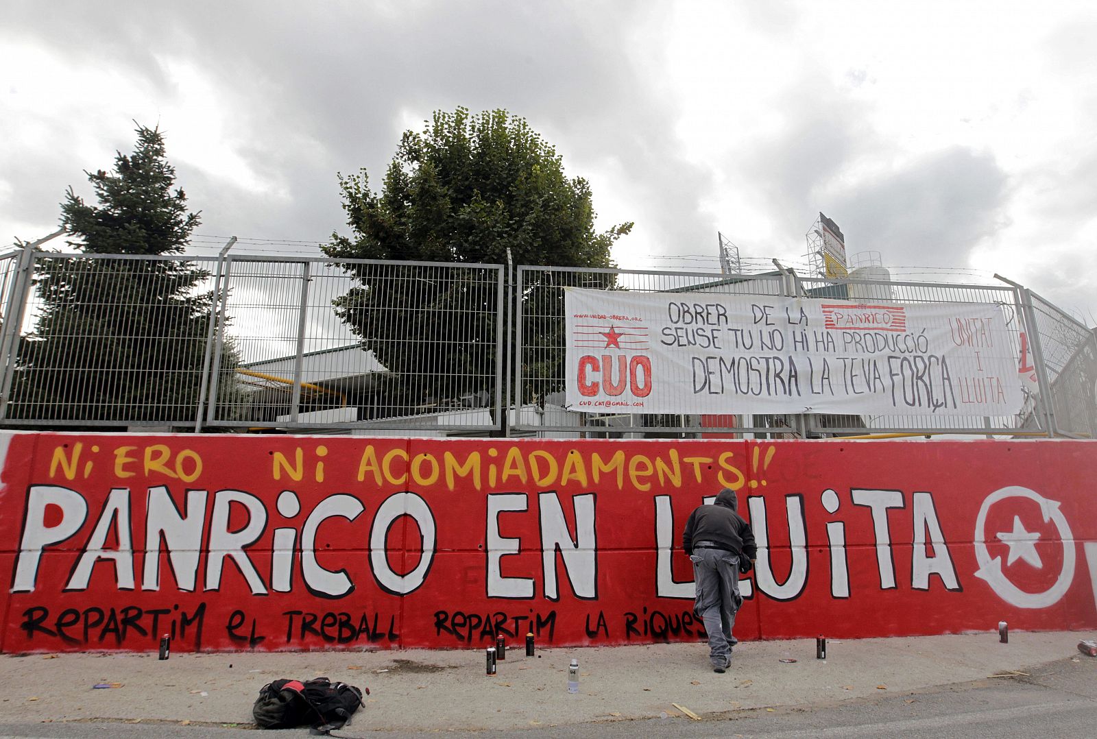 Un trabajador pinta un mural de apoyo a la plantilla en la fábrica de Panrico en Santa Perpètua.