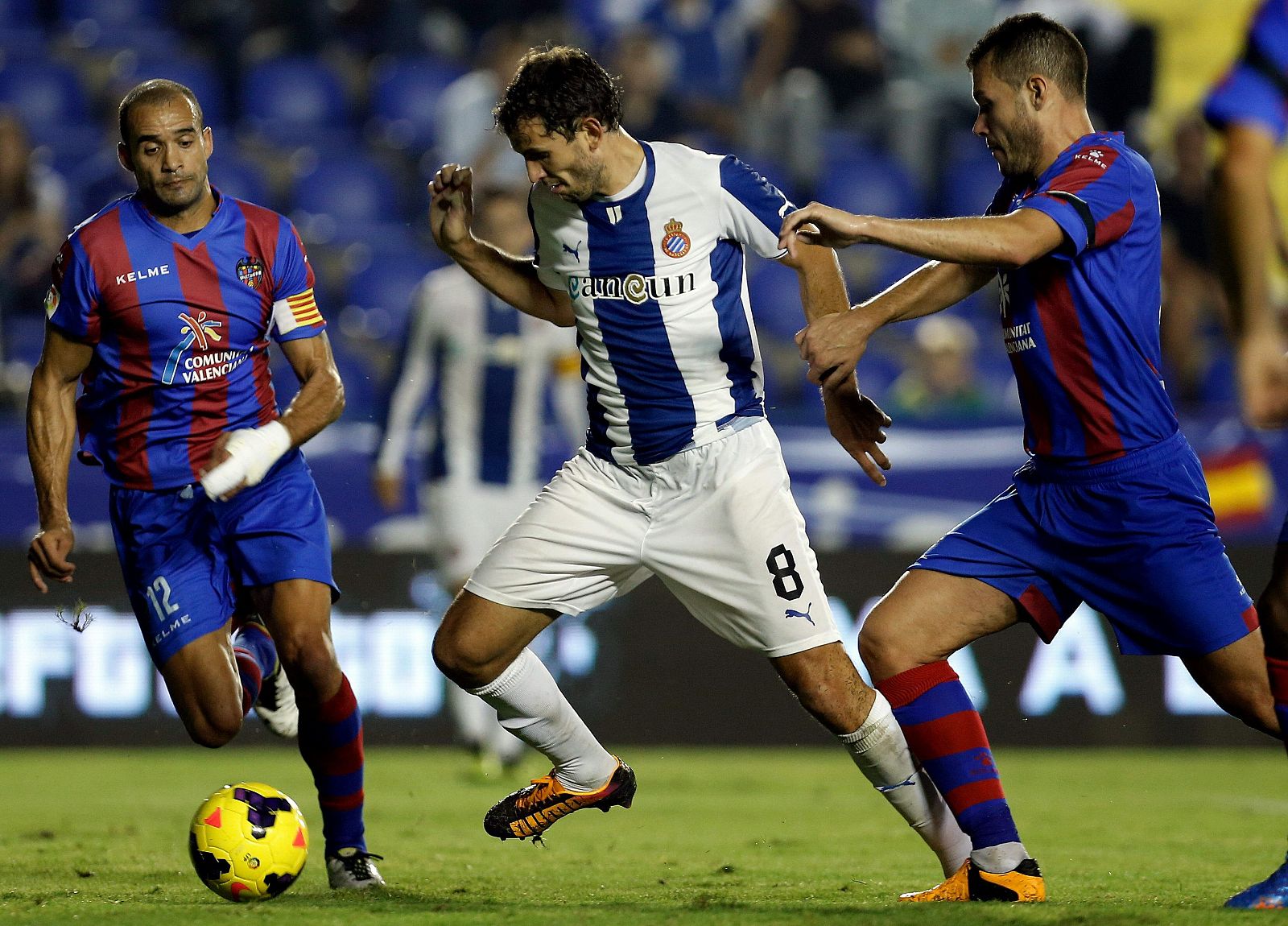 El delantero uruguayo del Espanyol, Christian Ricardo Stuani, intenta llevarse el balón ante los defensas del Levante, David Navarro y Juanfran.