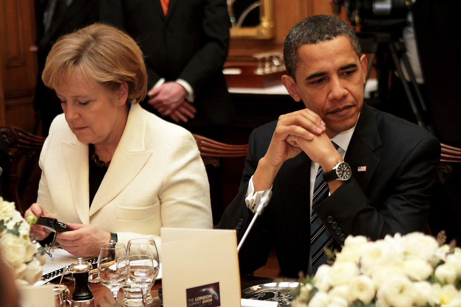 La canciller alemana, Angela Merkel, consulta su móvil sentada junto al presidente Barack Obama