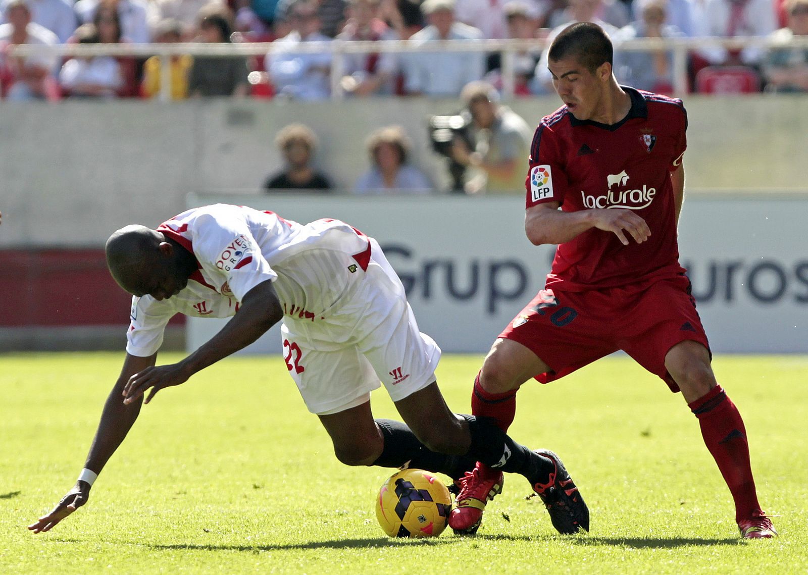 El centrocampista camerunés del Sevilla, Stephane Mbia, y el chileno del Osasuna, Francisco Silva, pelean por el balón.