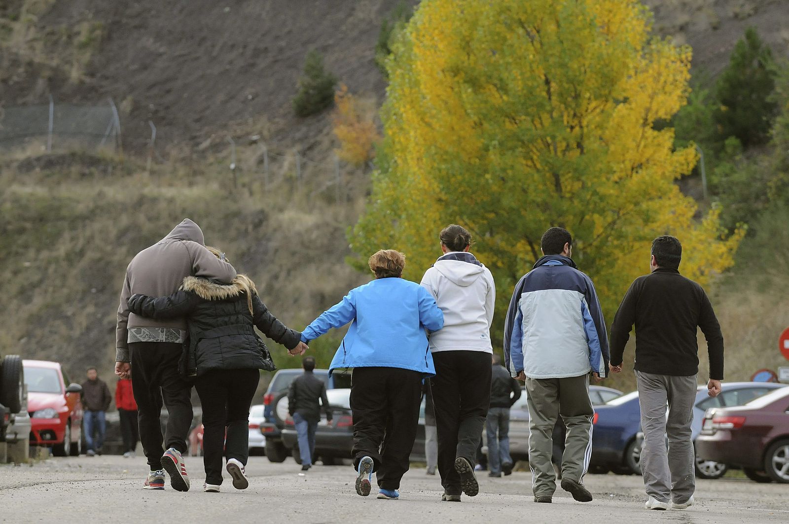 Un grupo de personas abandonan la mina abrazados