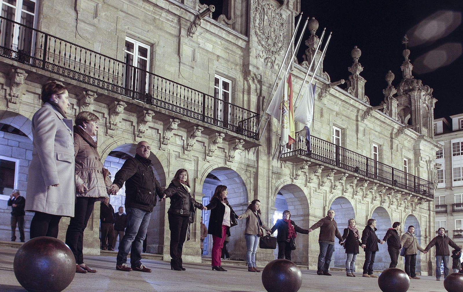 Varias personas rodean el Ayuntamiento de Lugo en señal de protesta por la reforma local
