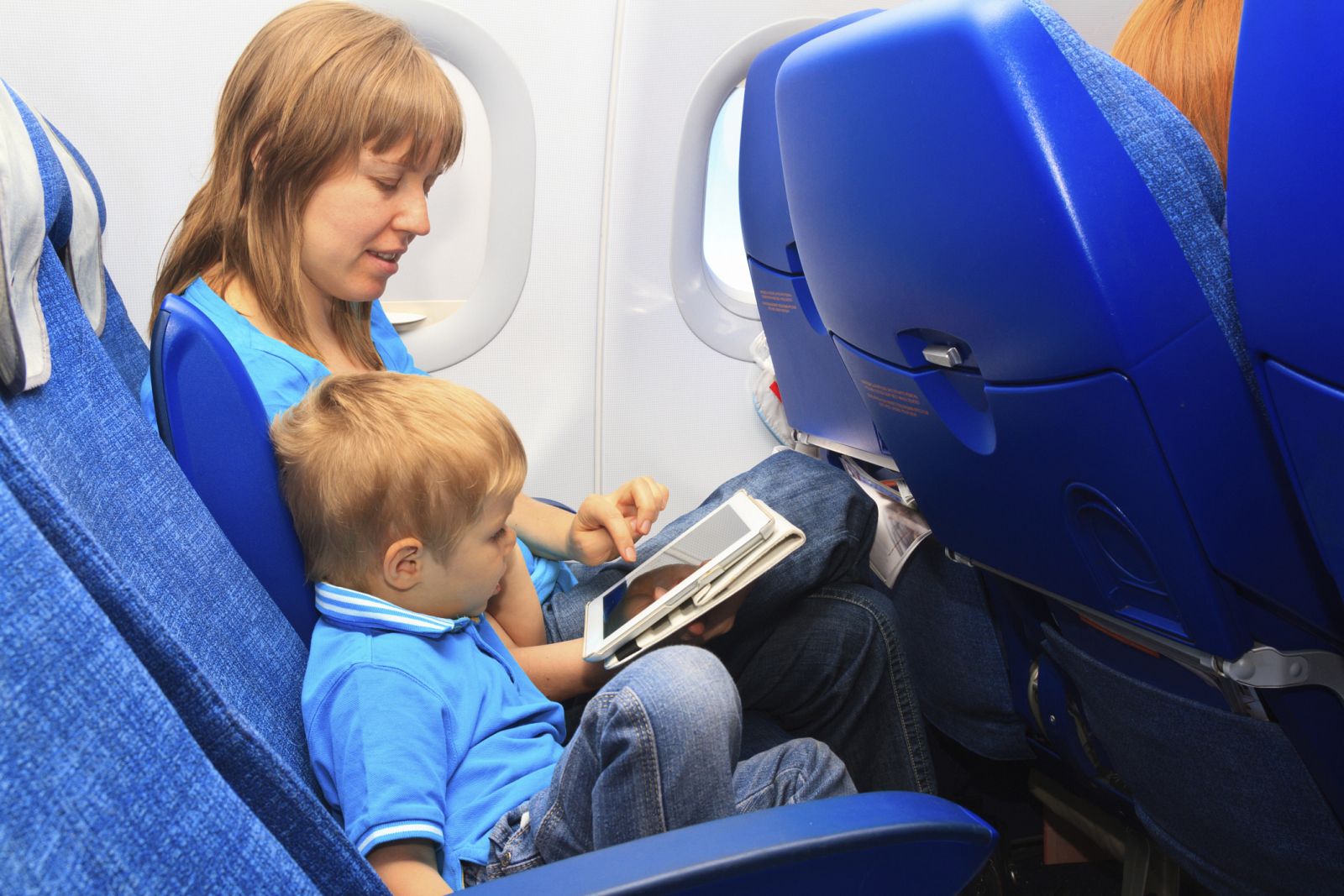 Una madre y su hijo con una tableta durante un vuelo.