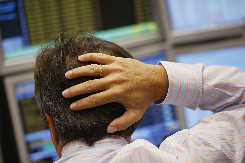 Un empleado de banca mira preocupado la pantalla de un ordenador