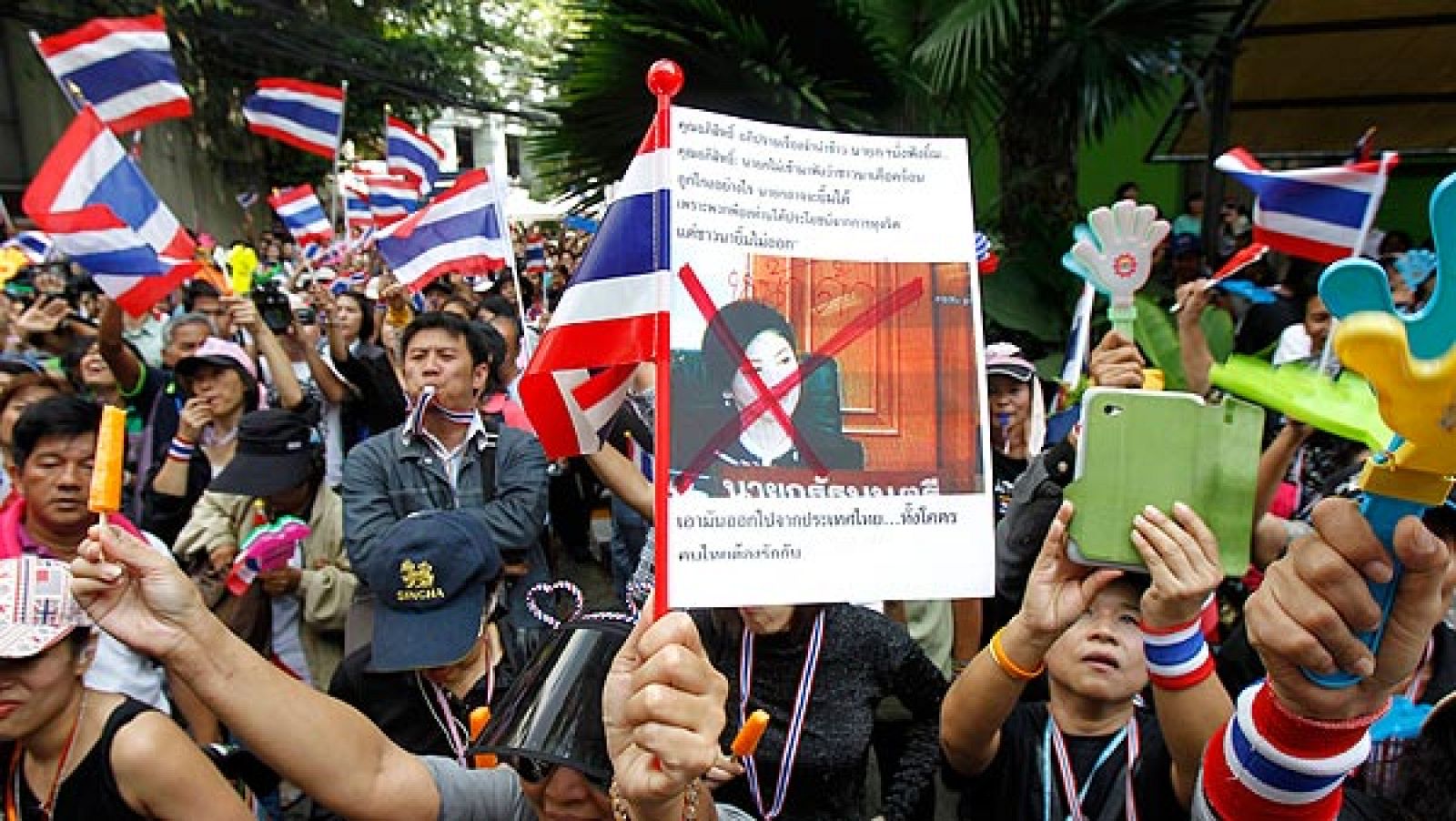 Manifestantes anti-gubernamentales en Tailandia muestran una fotografía tachada de la primera ministra, Yingluck Shinawatra
