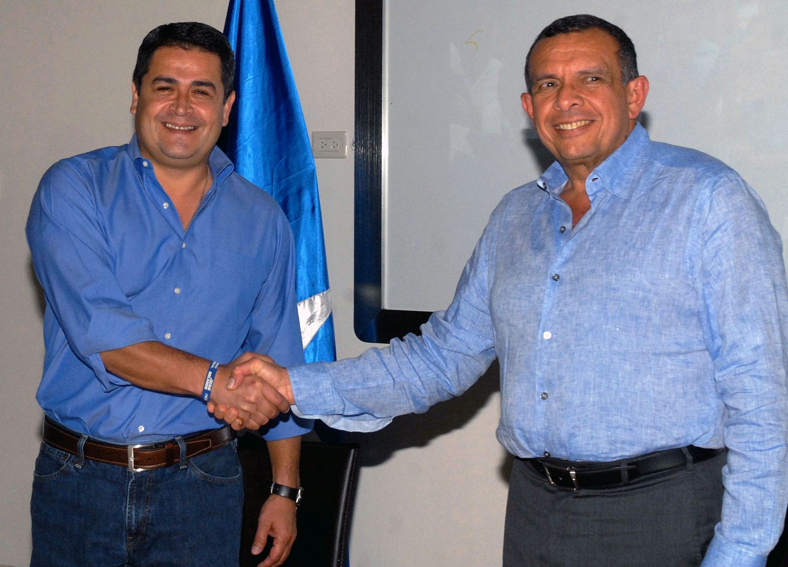 El PResidente de Honduras, Porfirio Lobo (derecha) estrecha su mano con el candidato presidencial del Partido Nacional, Juan Orlando Hernández, en Tegucigalpa