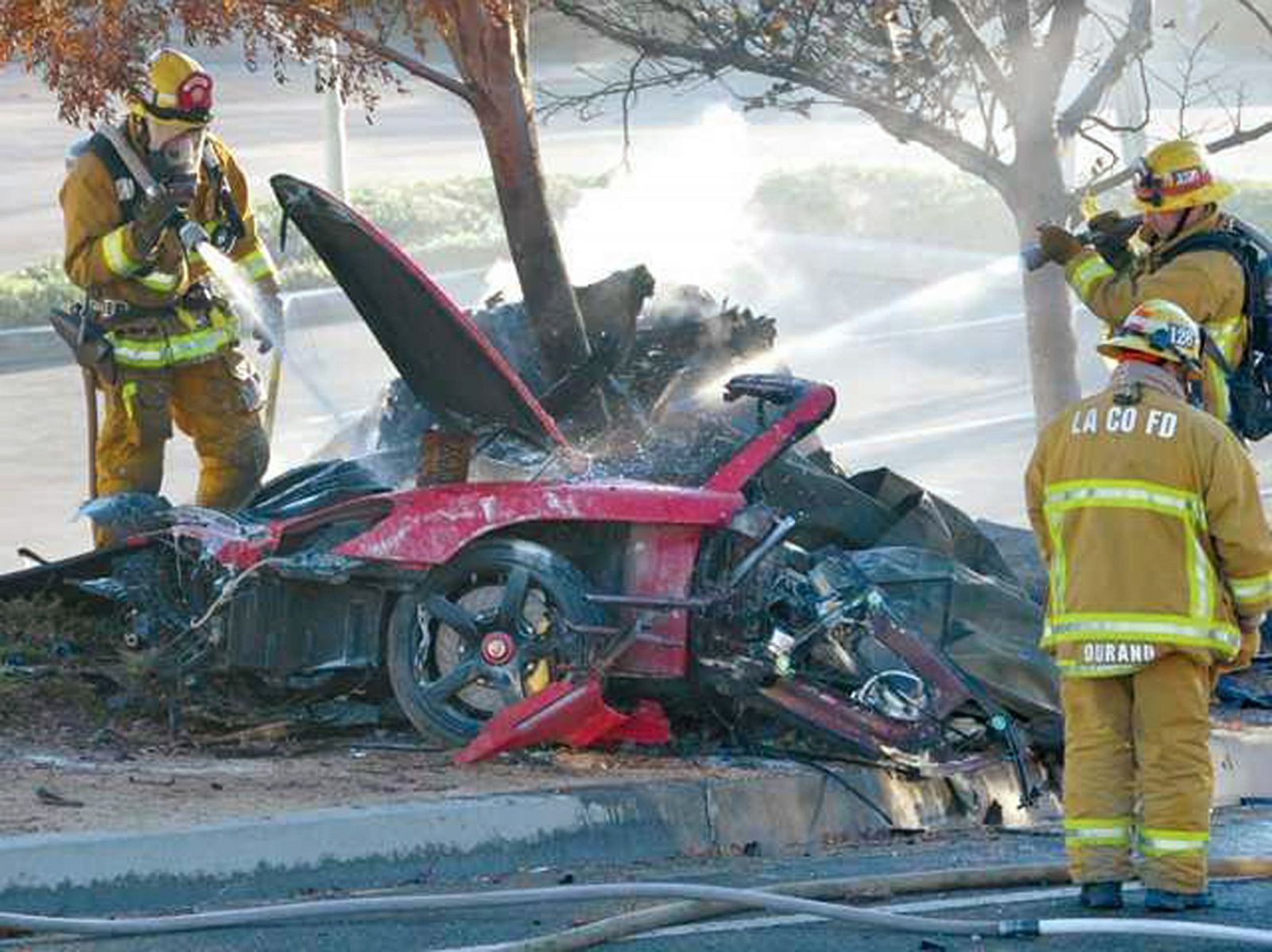 Firefighters extinguish the fire in the car where actor Paul Walker was killed along with another unidentified man during a car crash in Valencia