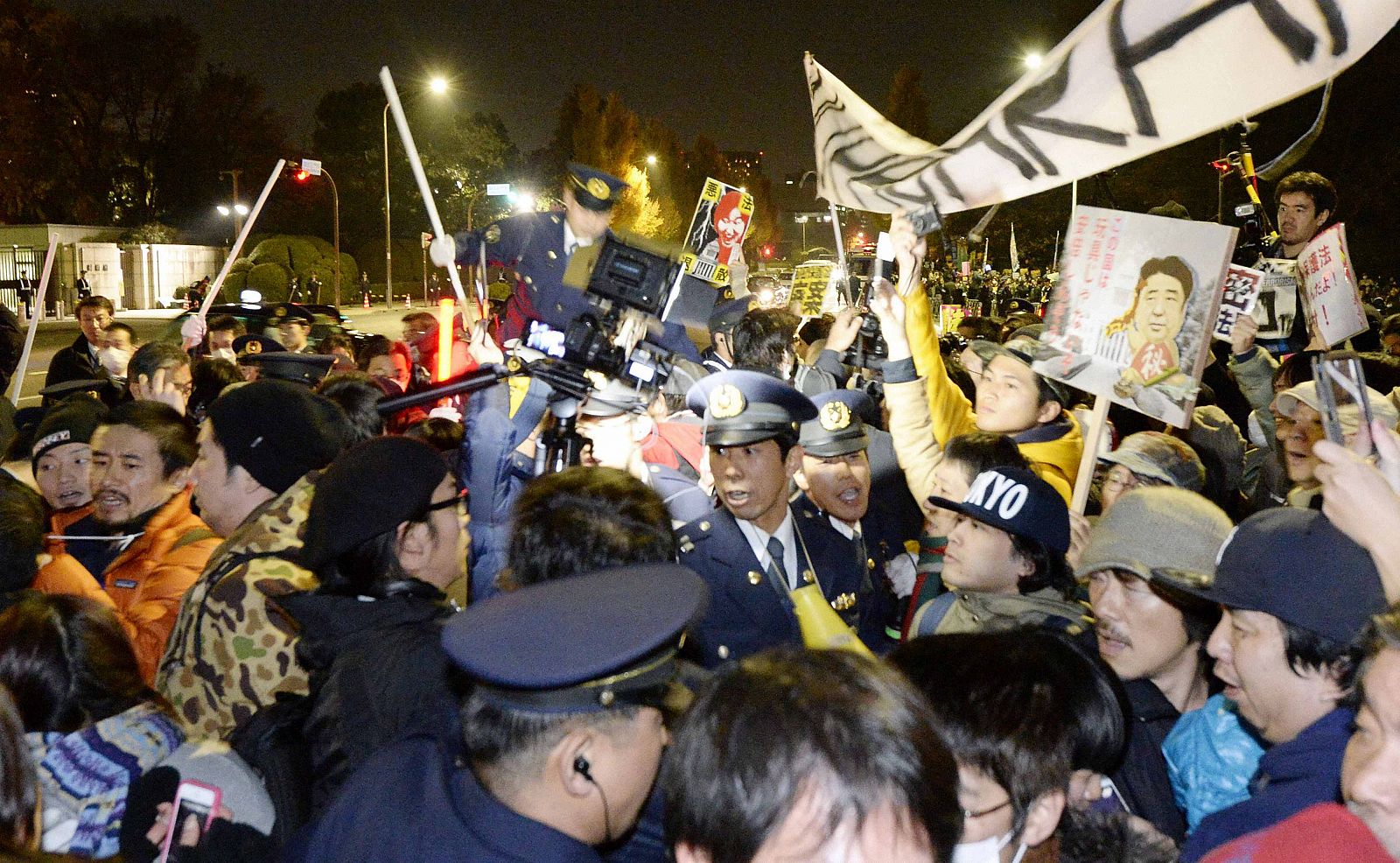 Protesters demonstrating against the proposed state secrets bill wrestle police officers in front of the parliament building in Tokyo