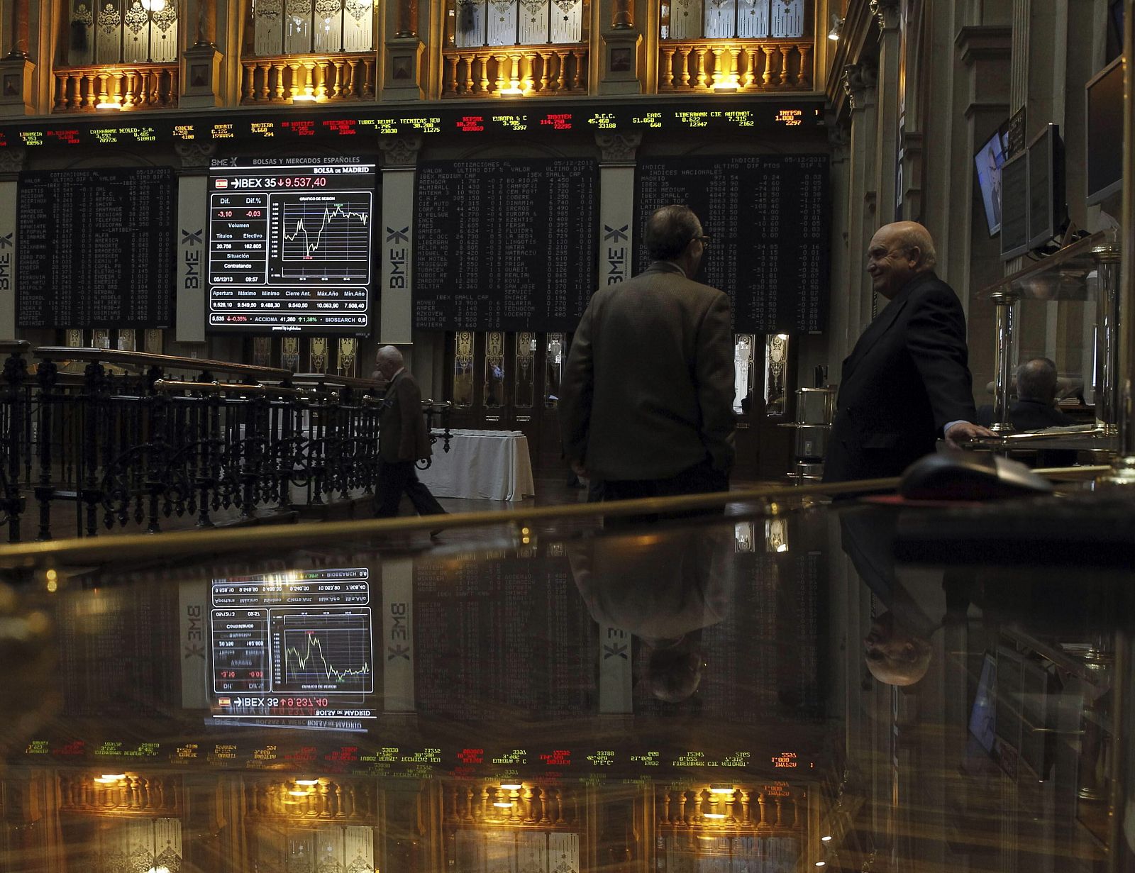 Inversores observan los paneles de la Bolsa de Madrid.