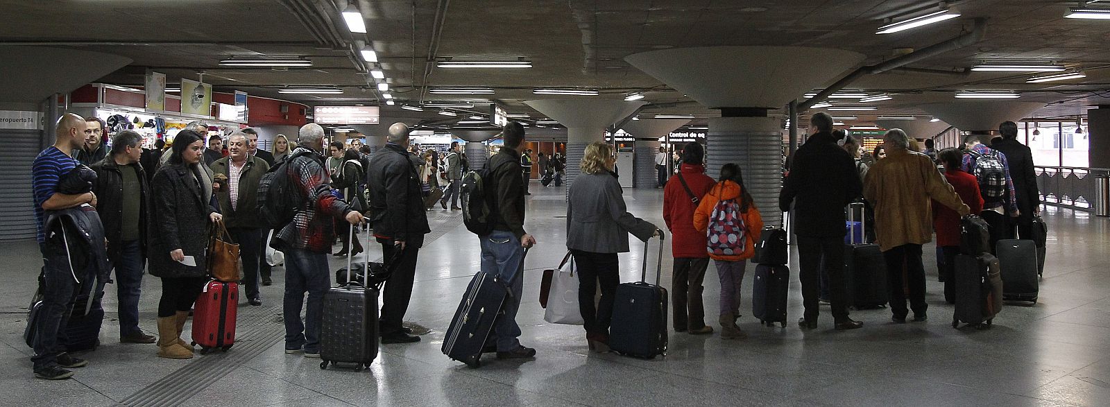 Un grupo de viajeros hacen cola en la estación de Atocha, en Madrid