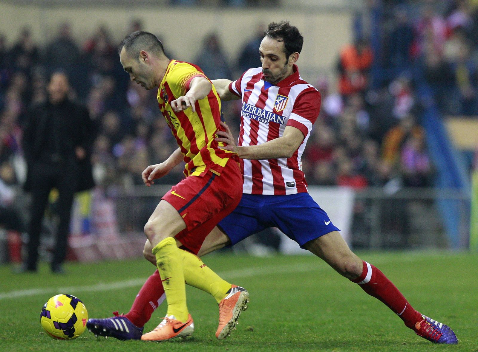 El centrocampista del FC Barcelona Andrés Iniesta (i) controla el balón ante Juanfran, del Atlético de Madrid