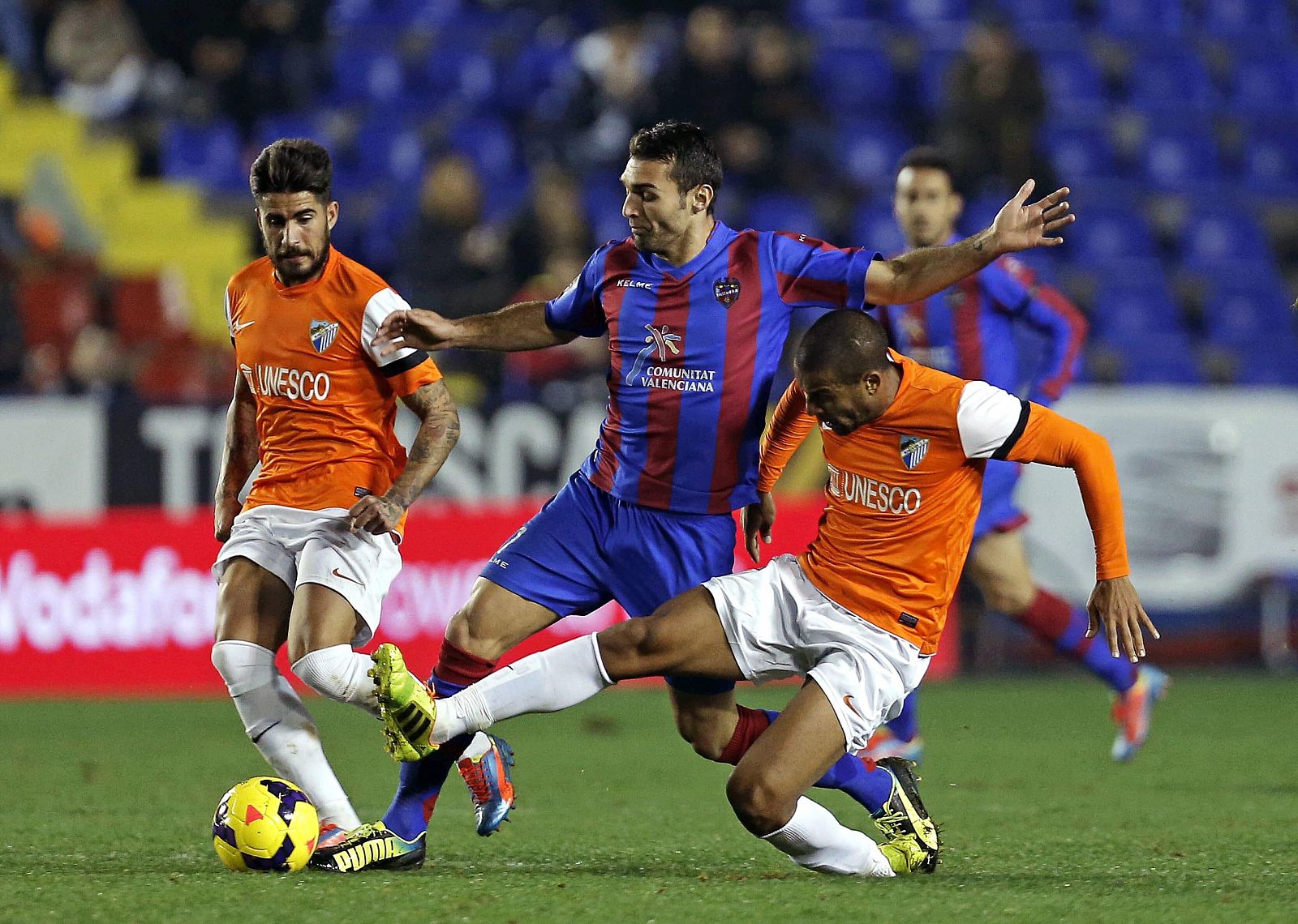 El delantero del Levante David Barral trata de superar la entrada del portugués Eliseu Pereira, del Málaga.