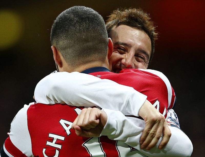 Alex Oxlade-Chamberlain, de espaldas, celebra uno de sus goles con Cazorla