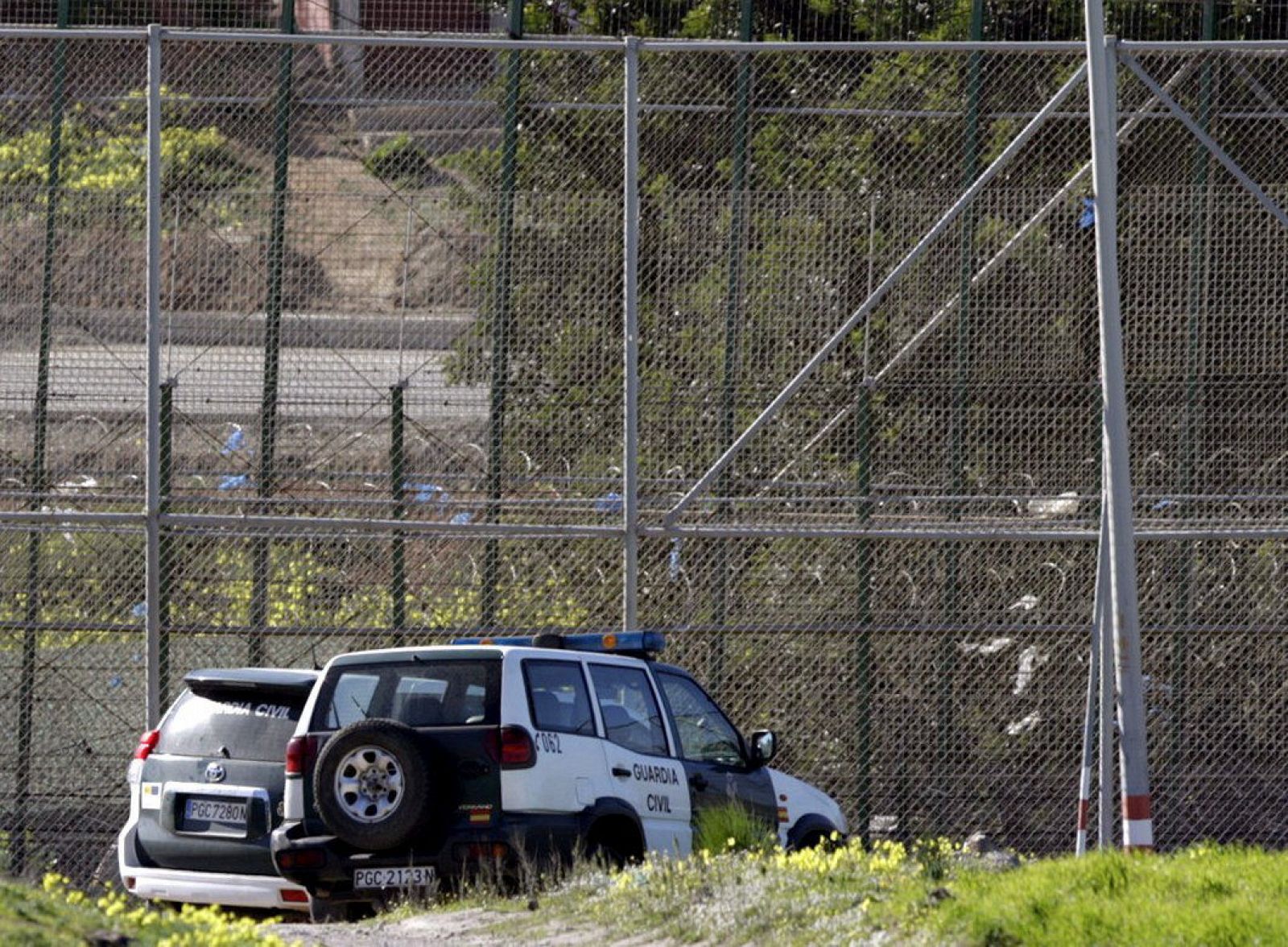 Varios coches de la Guardia Civil aparcados junto a la valla de Melilla