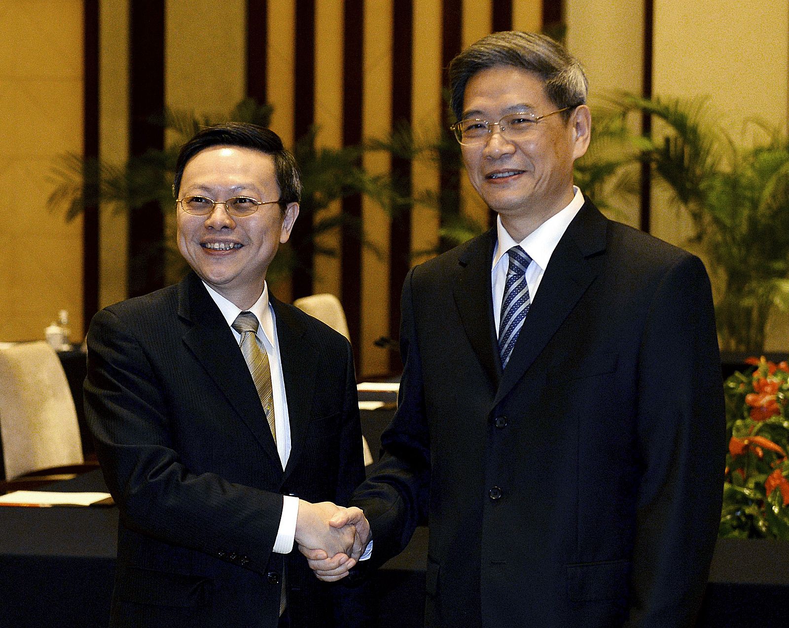 El respresentante de Taiwan, Wang Yu-chi (izda) y el de China, Zhang Zhijun, en la reunión bilateral