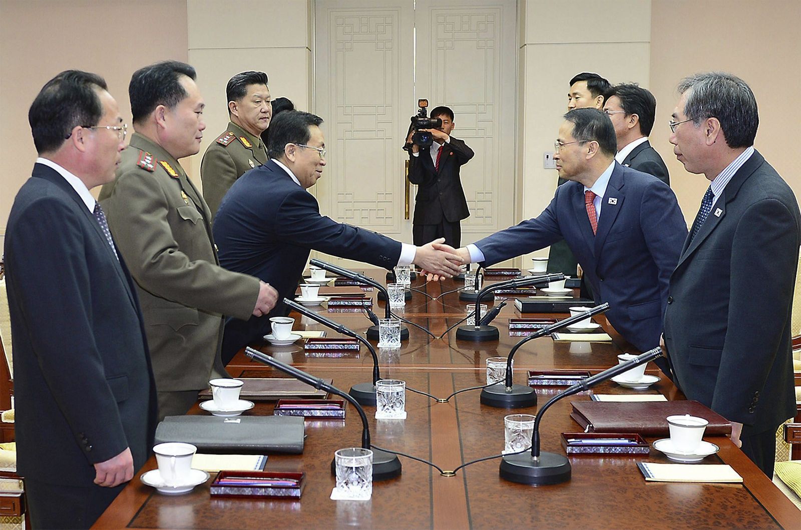 Fotografía facilitada por el Ministerio surcoreano de Unificación que muestra al jefe de la delegación surcoreana, Kim Kyou-hyun estrechando la mano de su homólogo norcoreano, Won Dong-yeon en Panmunjom.