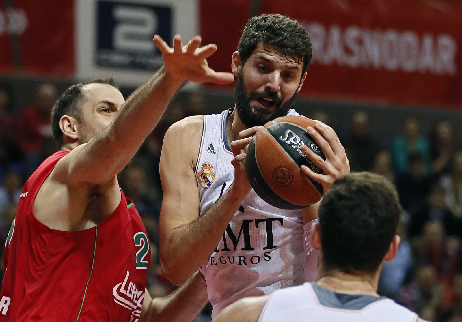 Nikola Mirotic (c), alero hispanomontenegrino del Real Madrid, lucha por el balón con Aleks Maric (i), del Lokomotiv Kuban