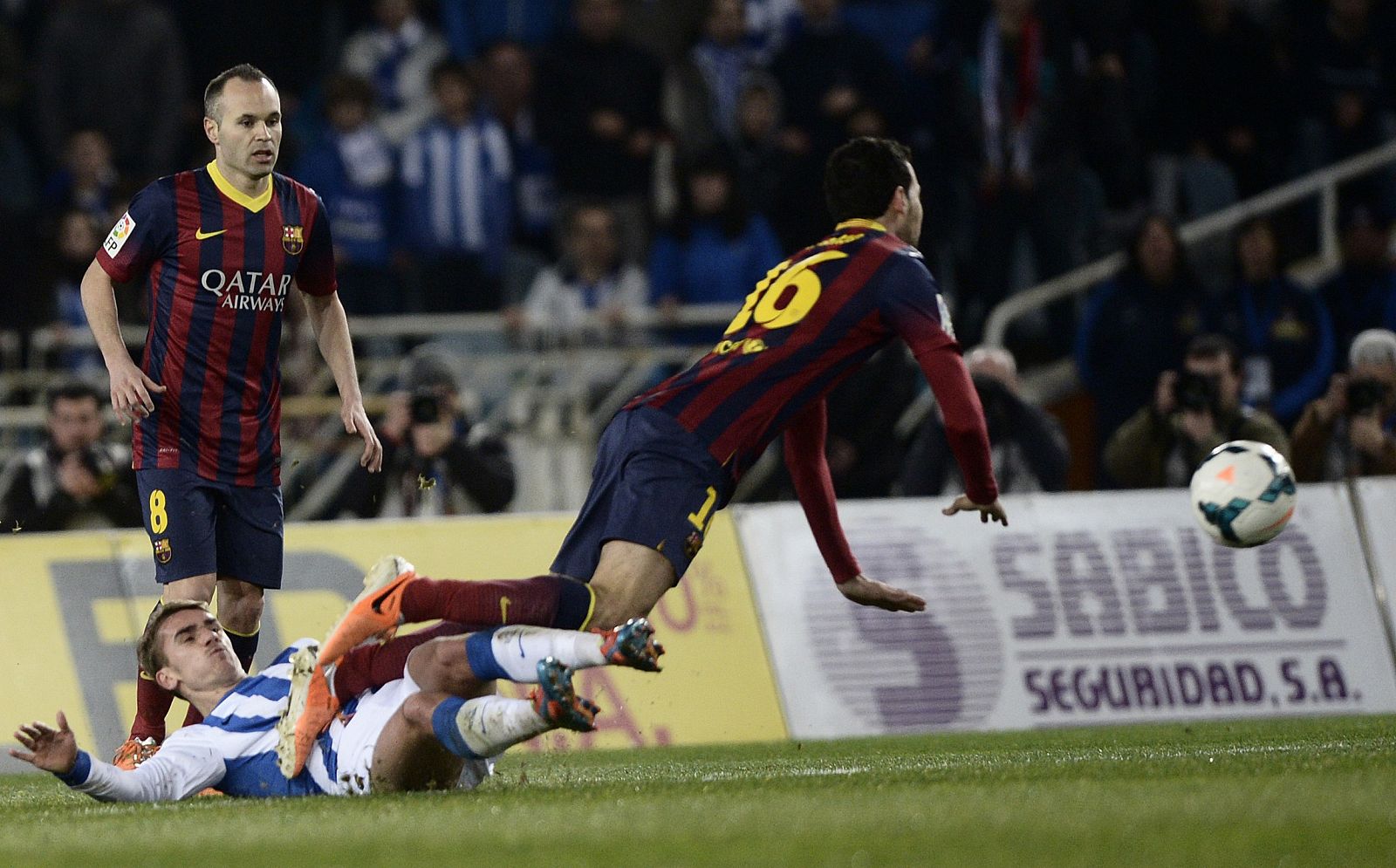 Barcelona's Busquets is tackled by Real Sociedad's Griezmann during their Spanish first division soccer match at Anoeta stadium in San Sebastian