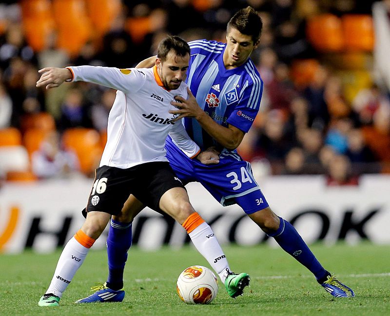 El delantero del Valencia, Paco Alcácer (i), protege el balón ante el defensa del Dinamo de Kiev, Yevgen Khackeridi