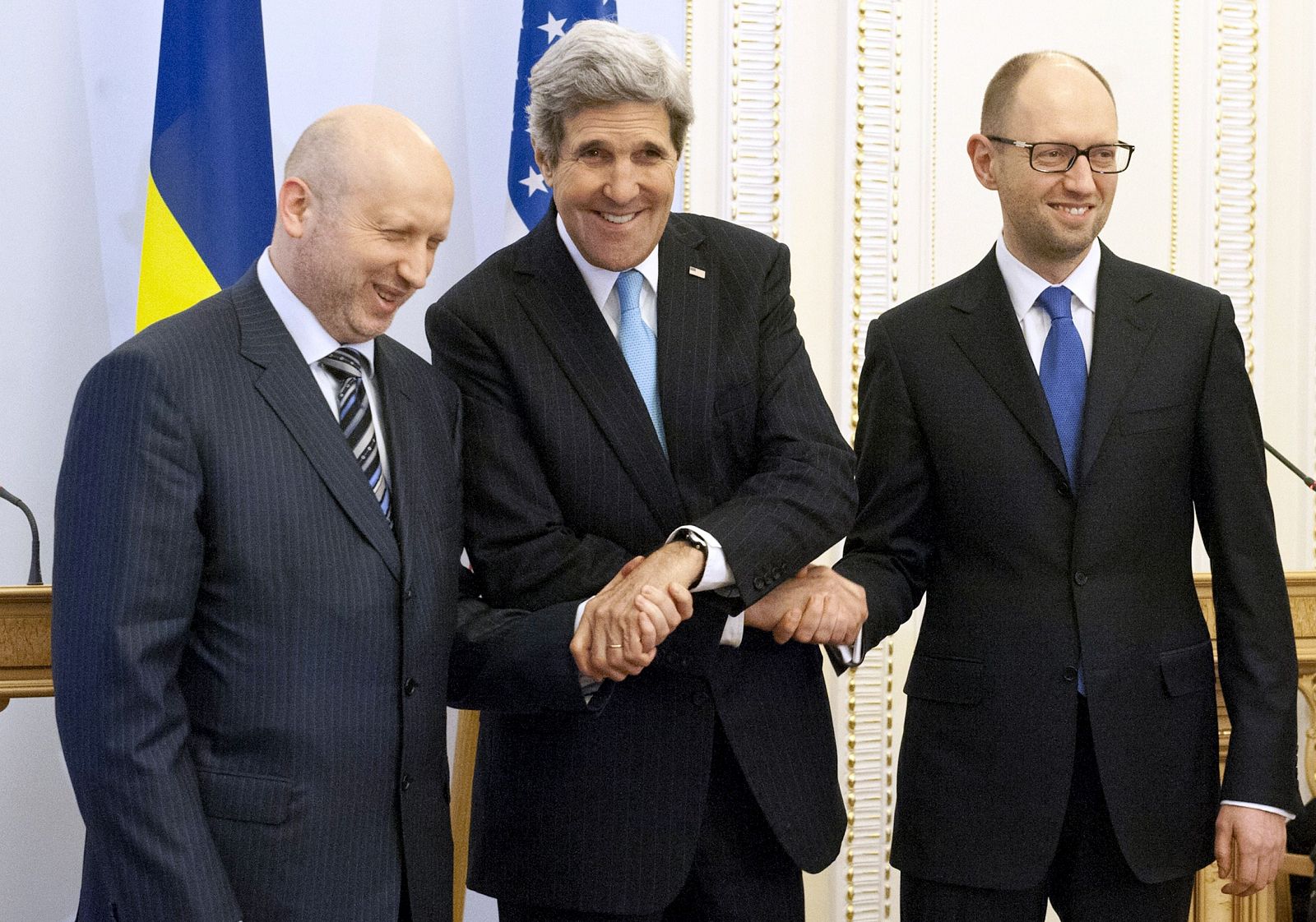 El secretario de Estado norteamericano, John Kerry, estrecha las manos del presidente en funciones ucraniano Alexánder Turchínov (izquierda) y el primer ministro Arseni Yatseniuk (derecho) en Kiev.